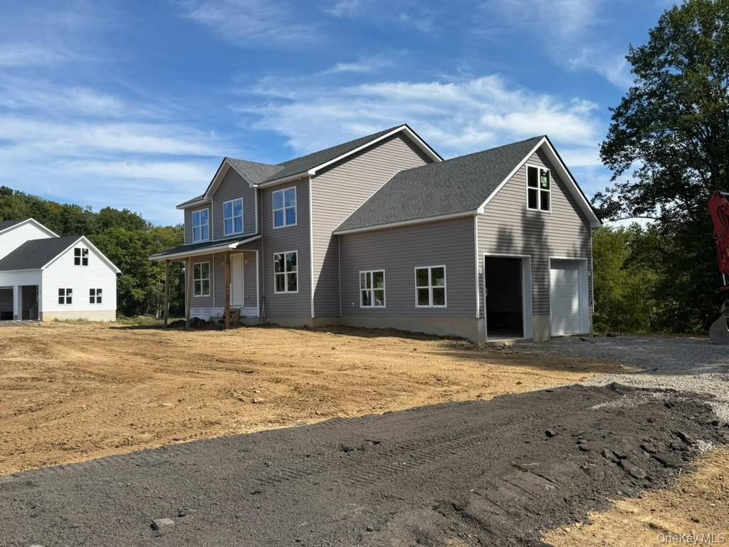 Newly constructed residence featuring gray siding and a dark shingle roof