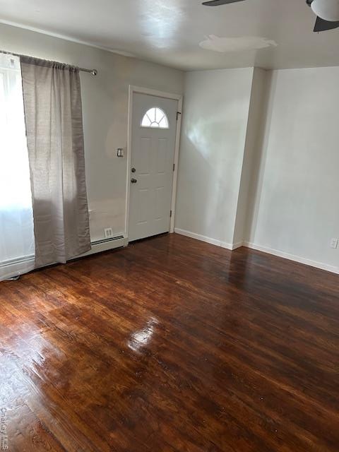 Foyer entrance with dark wood-style flooring and baseboards