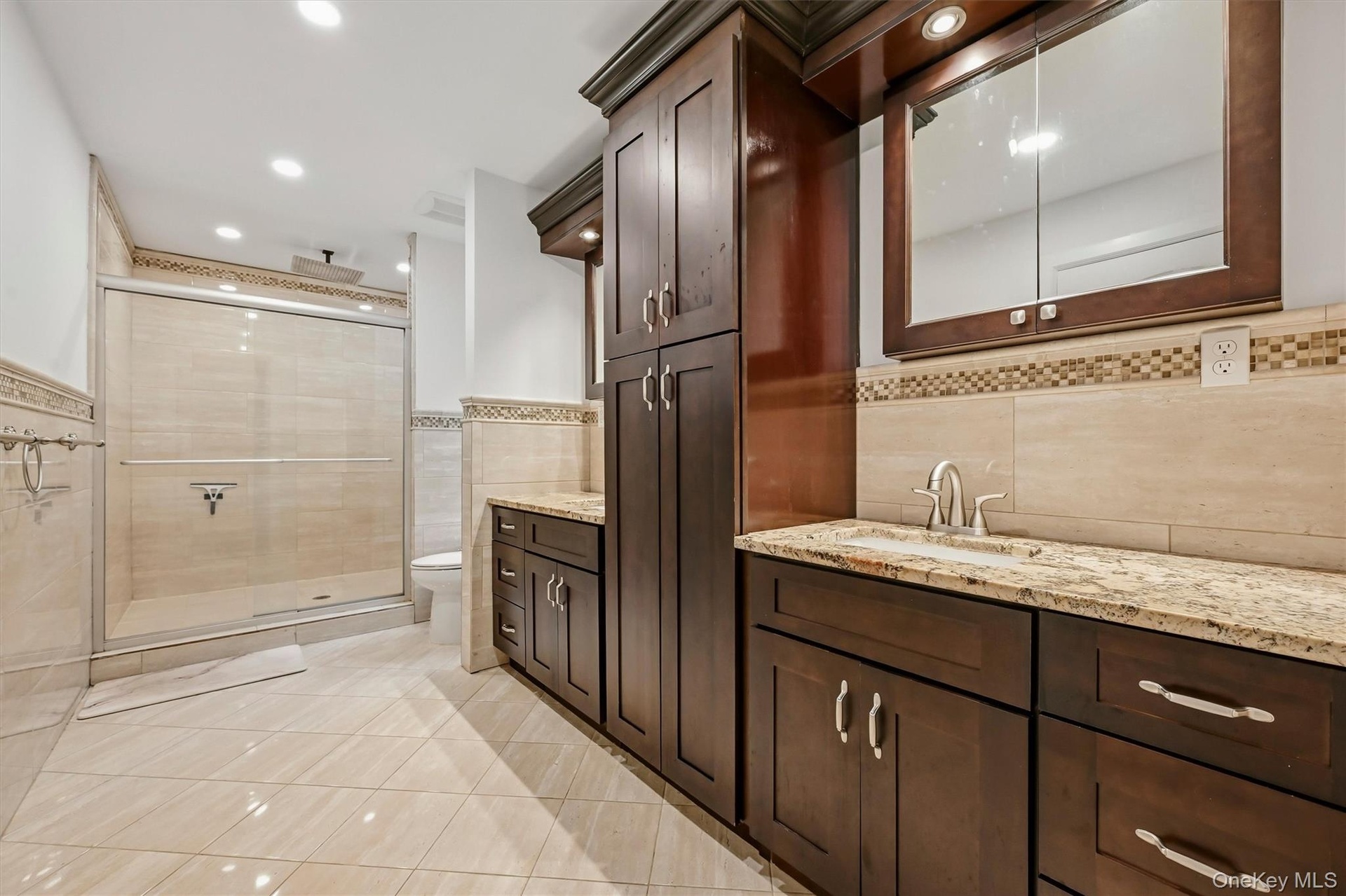 Primary bathroom with granite vanities, marble tile oversized shower with rainfall shower head. WIC access in primary bath.