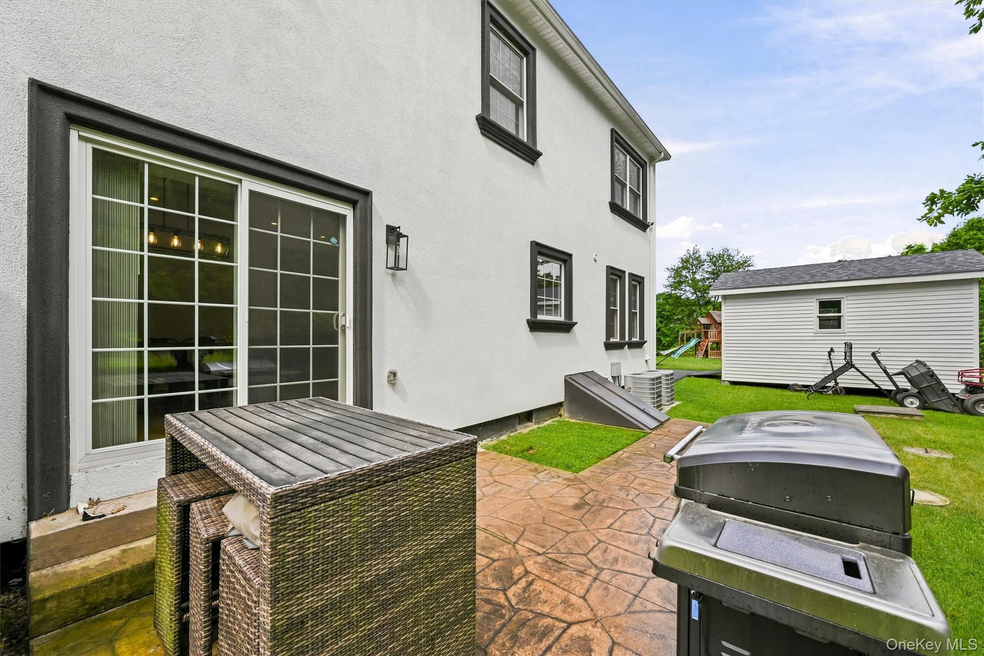Stucco exterior, back Anderson slider, shed, stamped concrete patio, Bilco door to crawl space ( standing room) Buried owned propane tank and access t