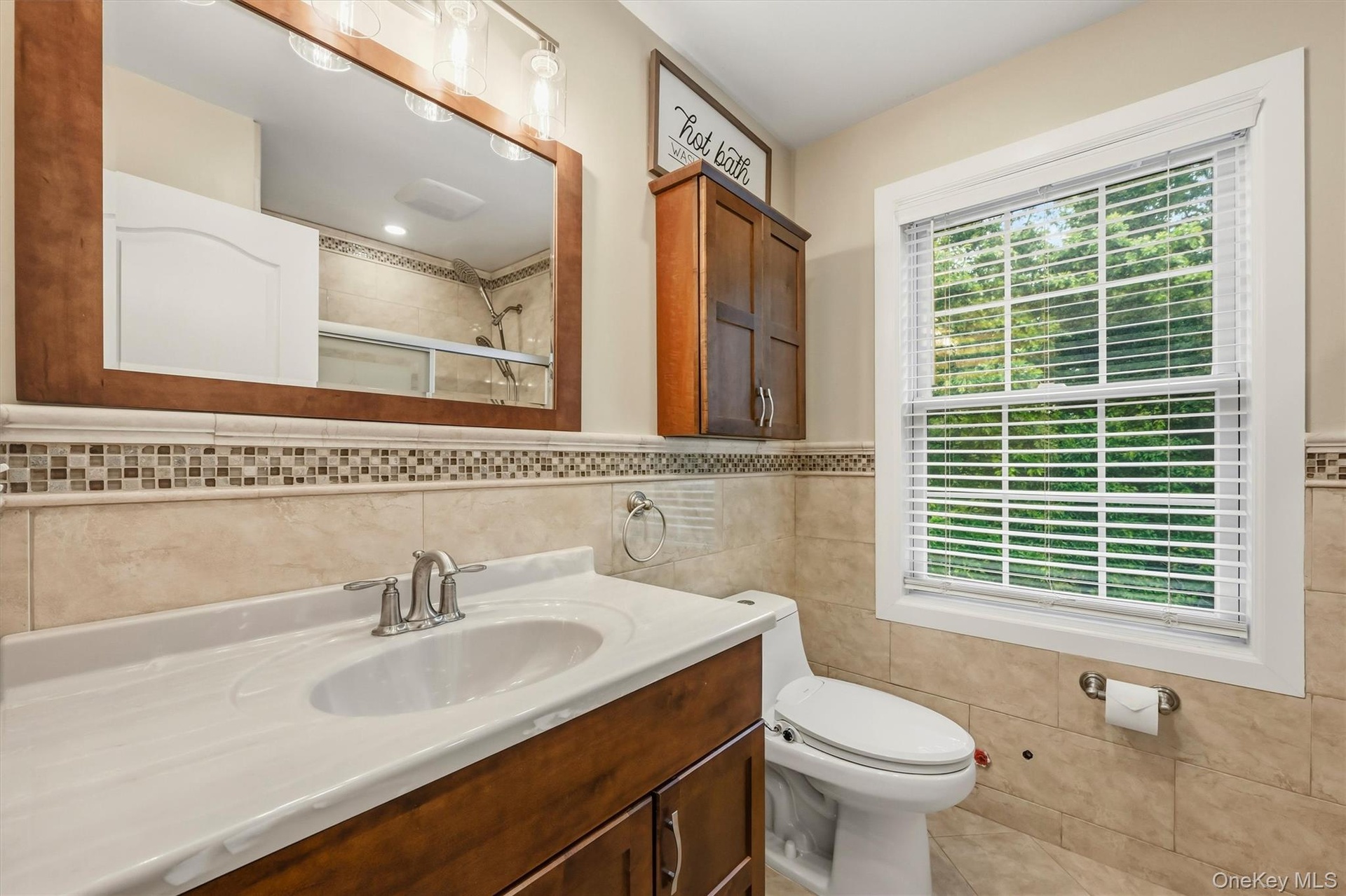 Hallway bathroom, marble tile, Anderson window, recessed lighting.