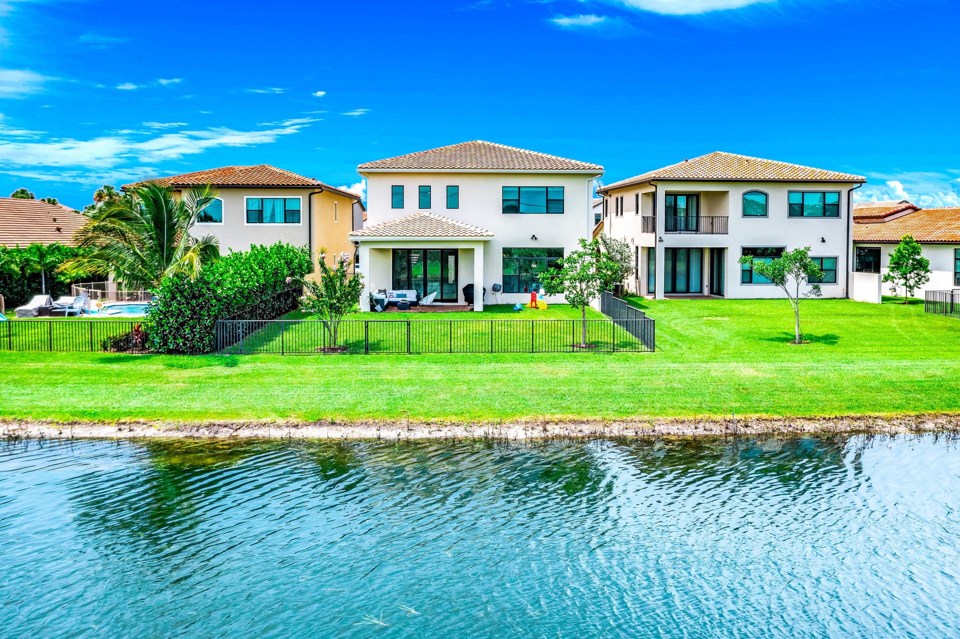 Expansive green lawn with water frontage and mature trees