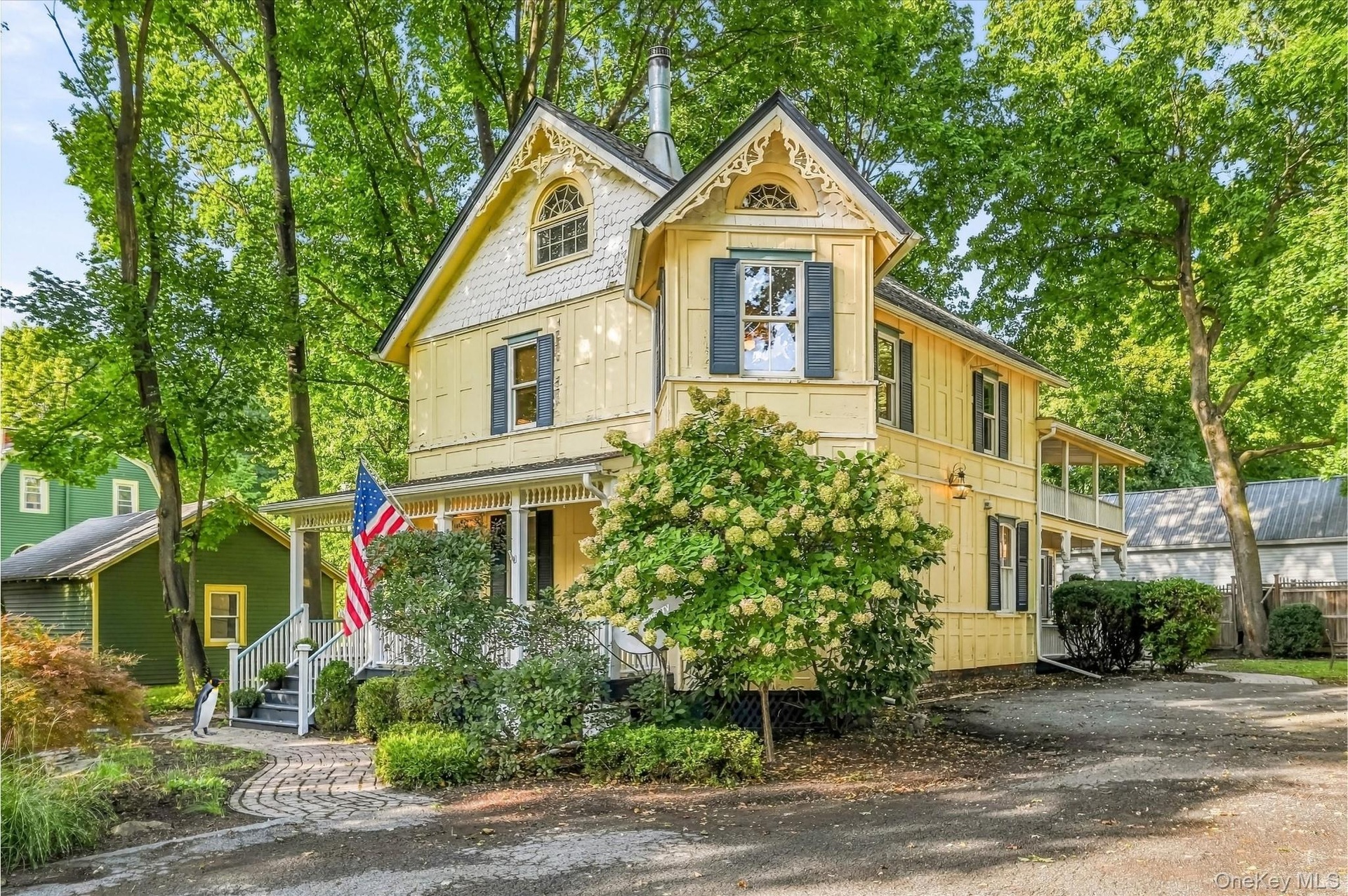 Victorian-style exterior with decorative gables, a covered porch, and mature landscaping