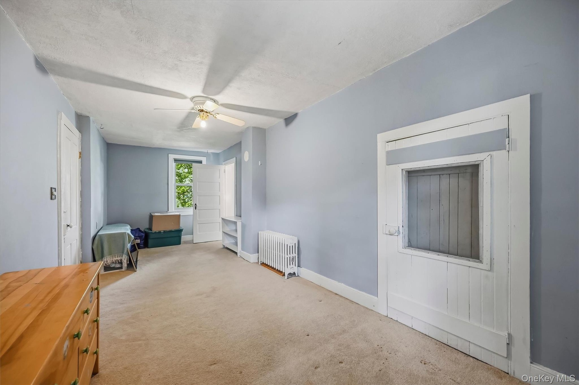 Ceiling fan light fixture, baseboard heating, window, white trim, and a built-in shelf