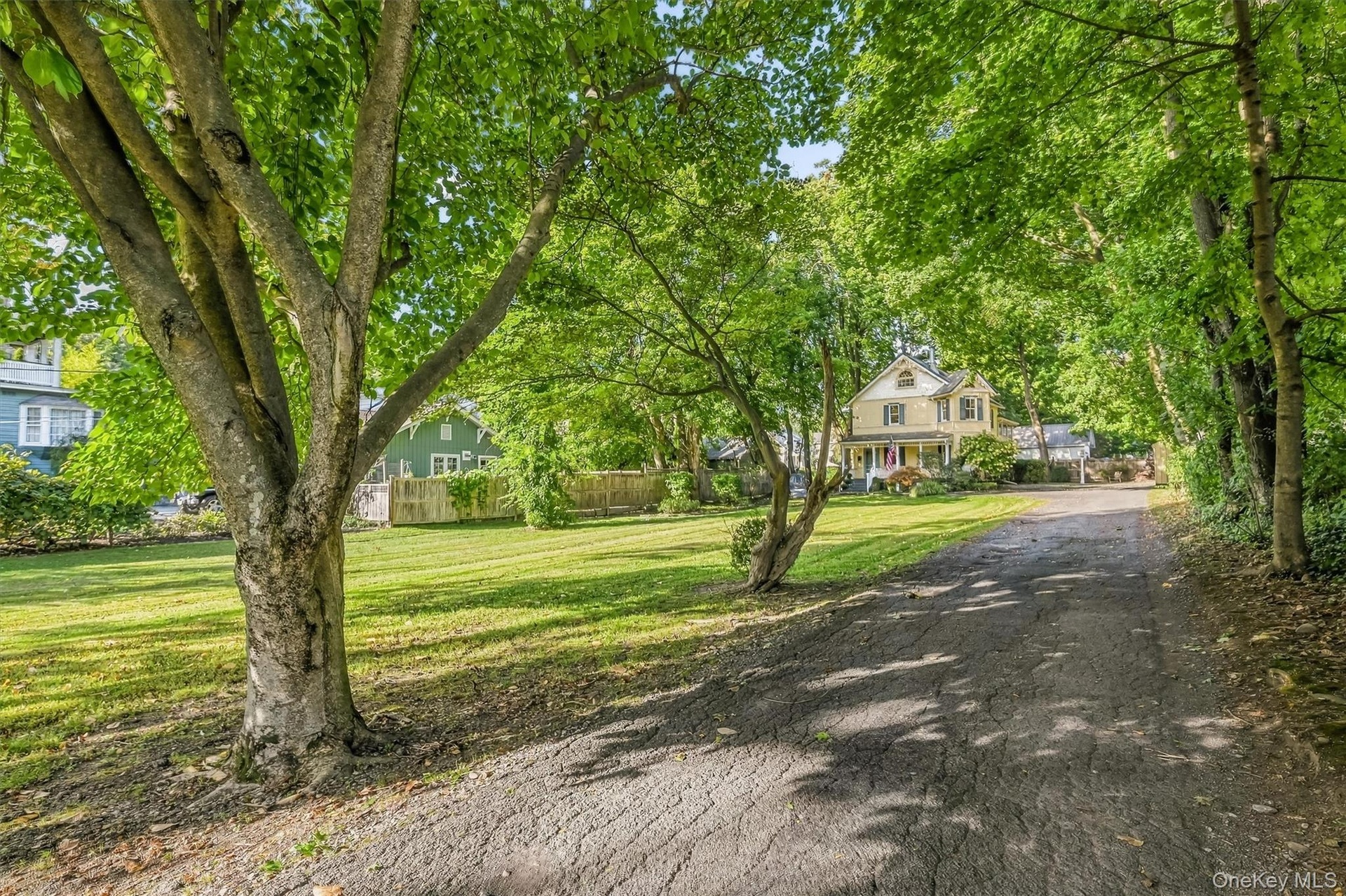 Tree-lined setting with a spacious lawn and long driveway