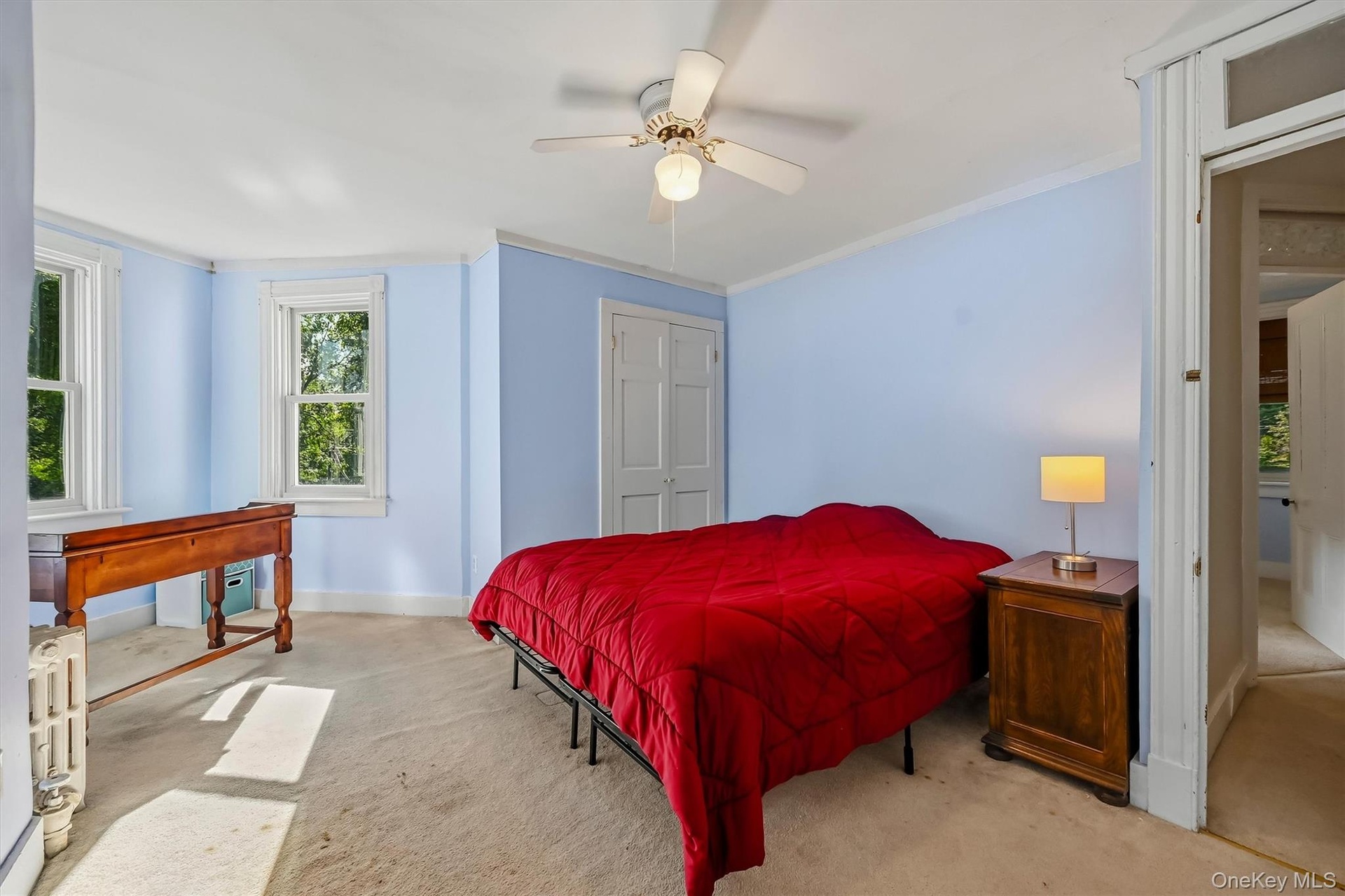 Spacious bedroom with multiple windows, abundant natural light, and a bright sitting area.