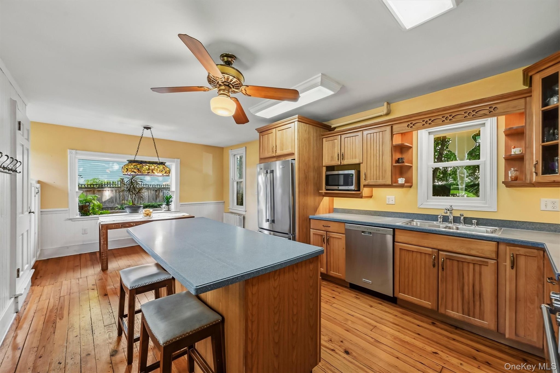 Bright kitchen with center island, stainless steel appliances and breakfast area