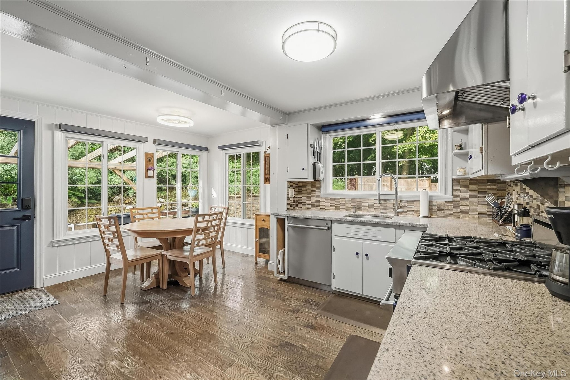 Large windows accent the gourmet kitchen and dining area filling the room with incredible natural sunlight.