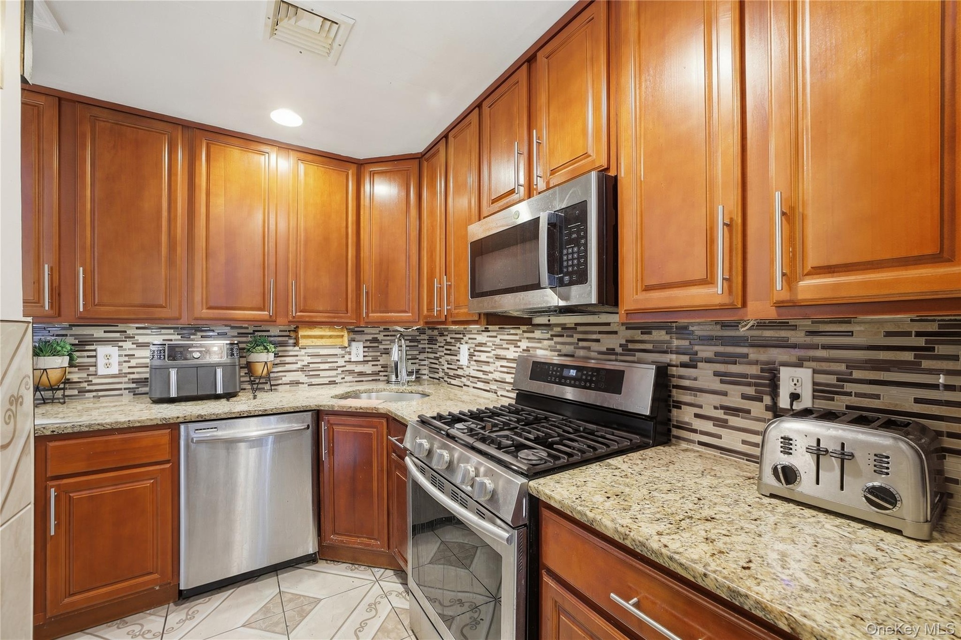 Unit 2 - Kitchen with stainless steel appliances. Digitally decluttered.