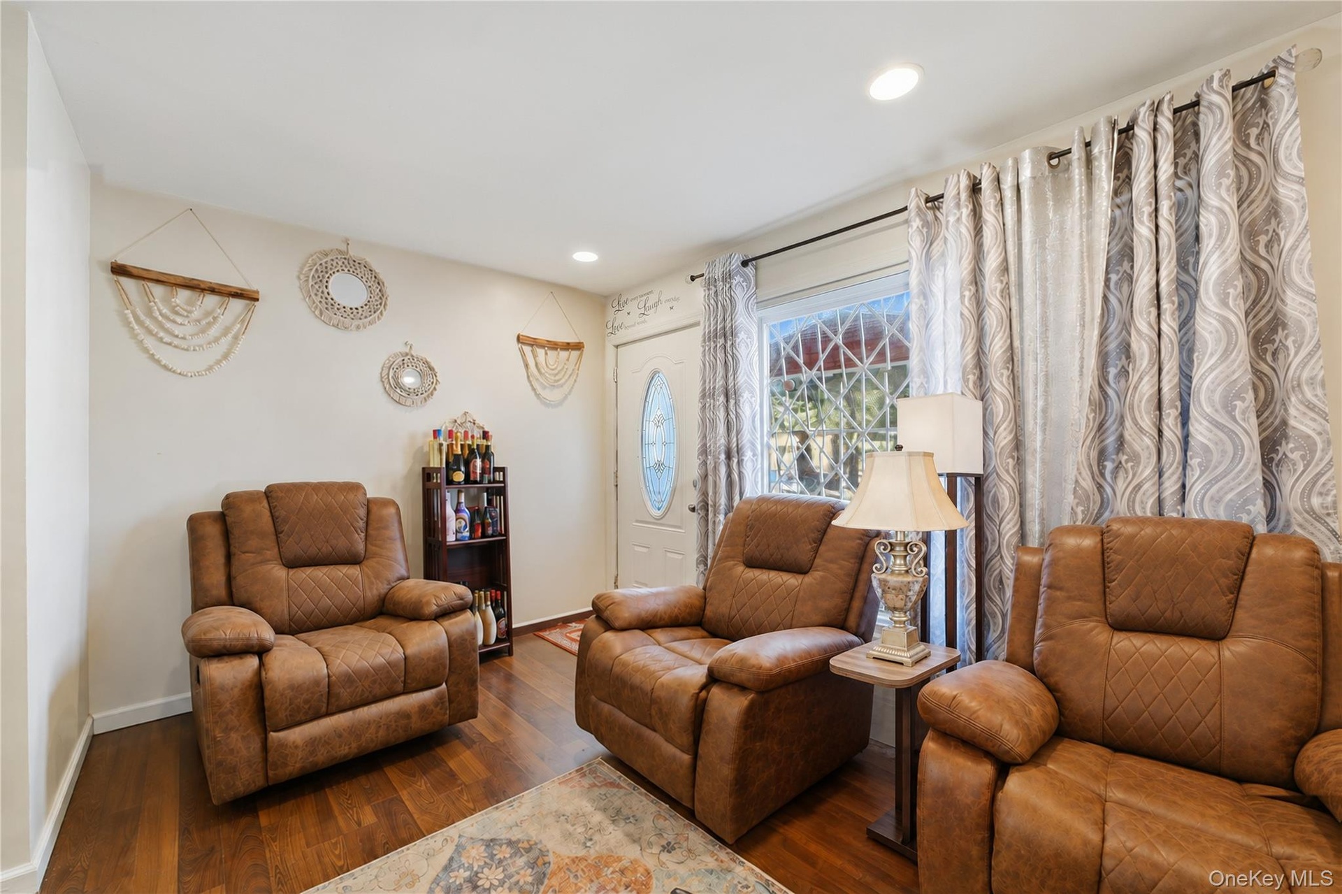 Unit 1 - Living room seating and front window. Digitally decluttered; some decor restyled.