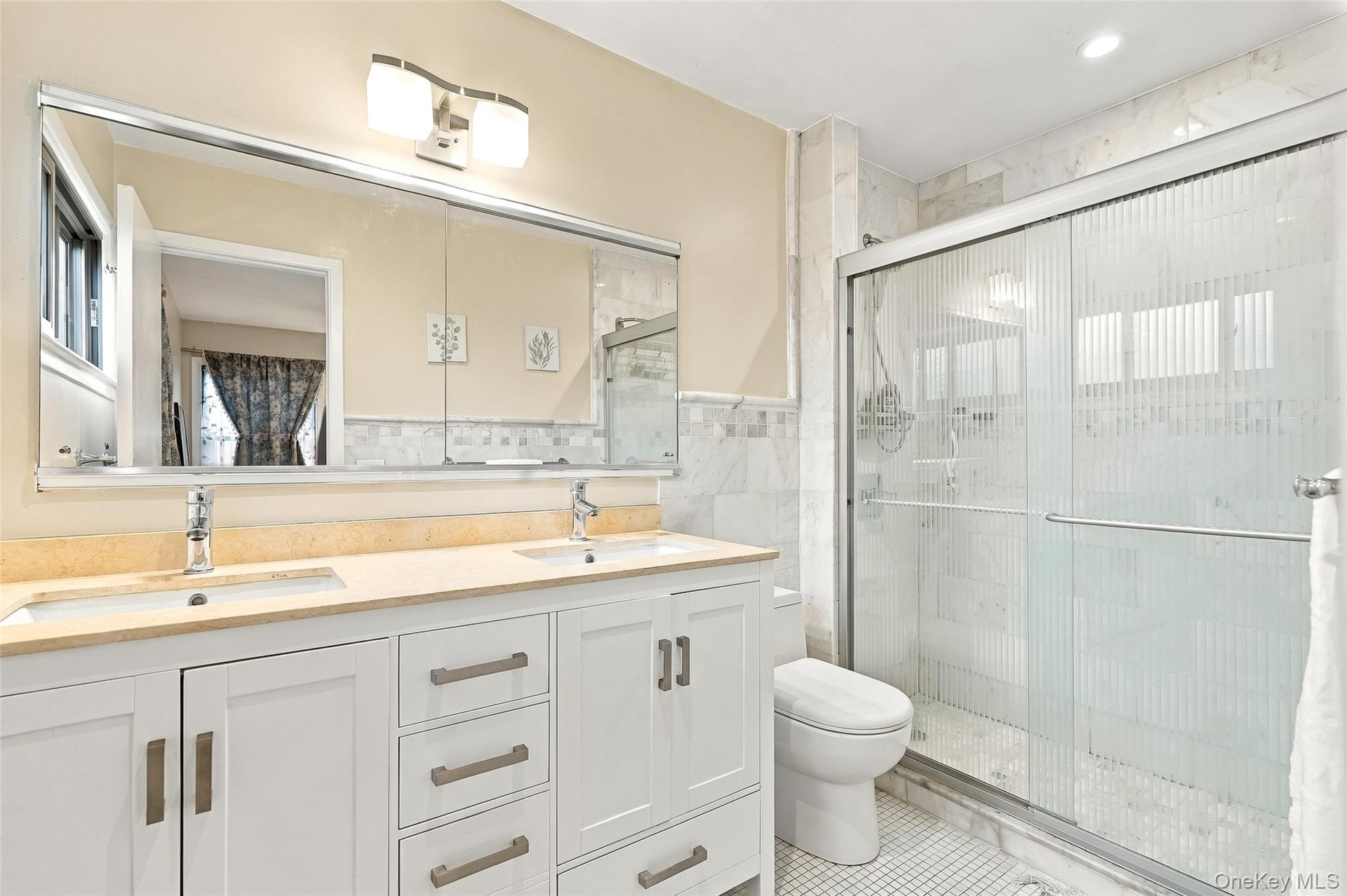 Primary ensuite bathroom with double sink vanity.