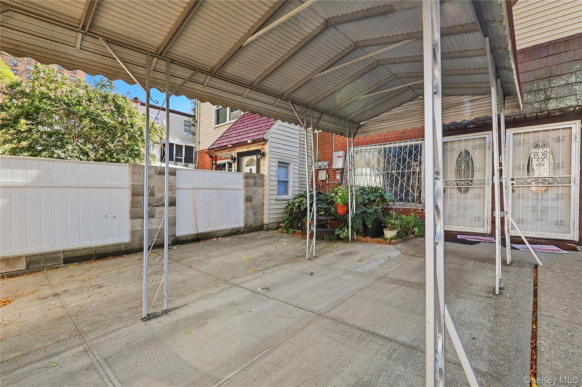 Covered front courtyard toward the entrance. Digitally decluttered.