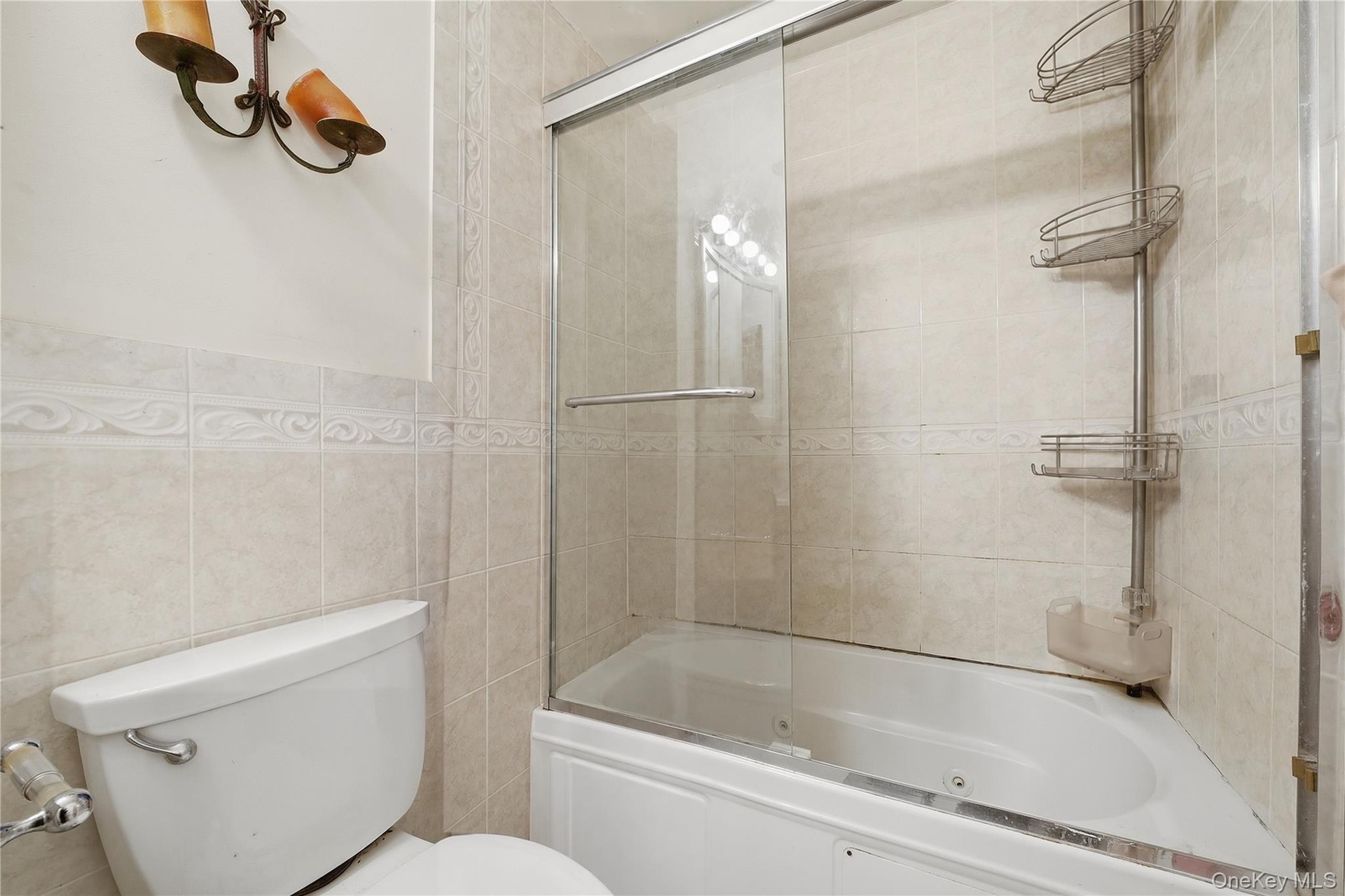 Unit 2 - Bathroom tub and glass enclosure, alternate view. Digitally decluttered.