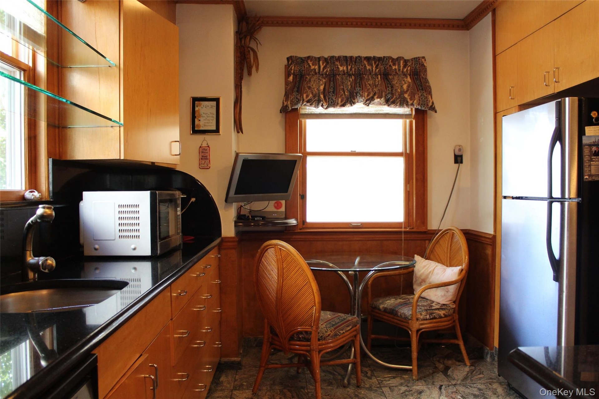 Birch wood-finish cabinetry with  trash compactor in sink   and granites tiles.All stainless steel  appliances