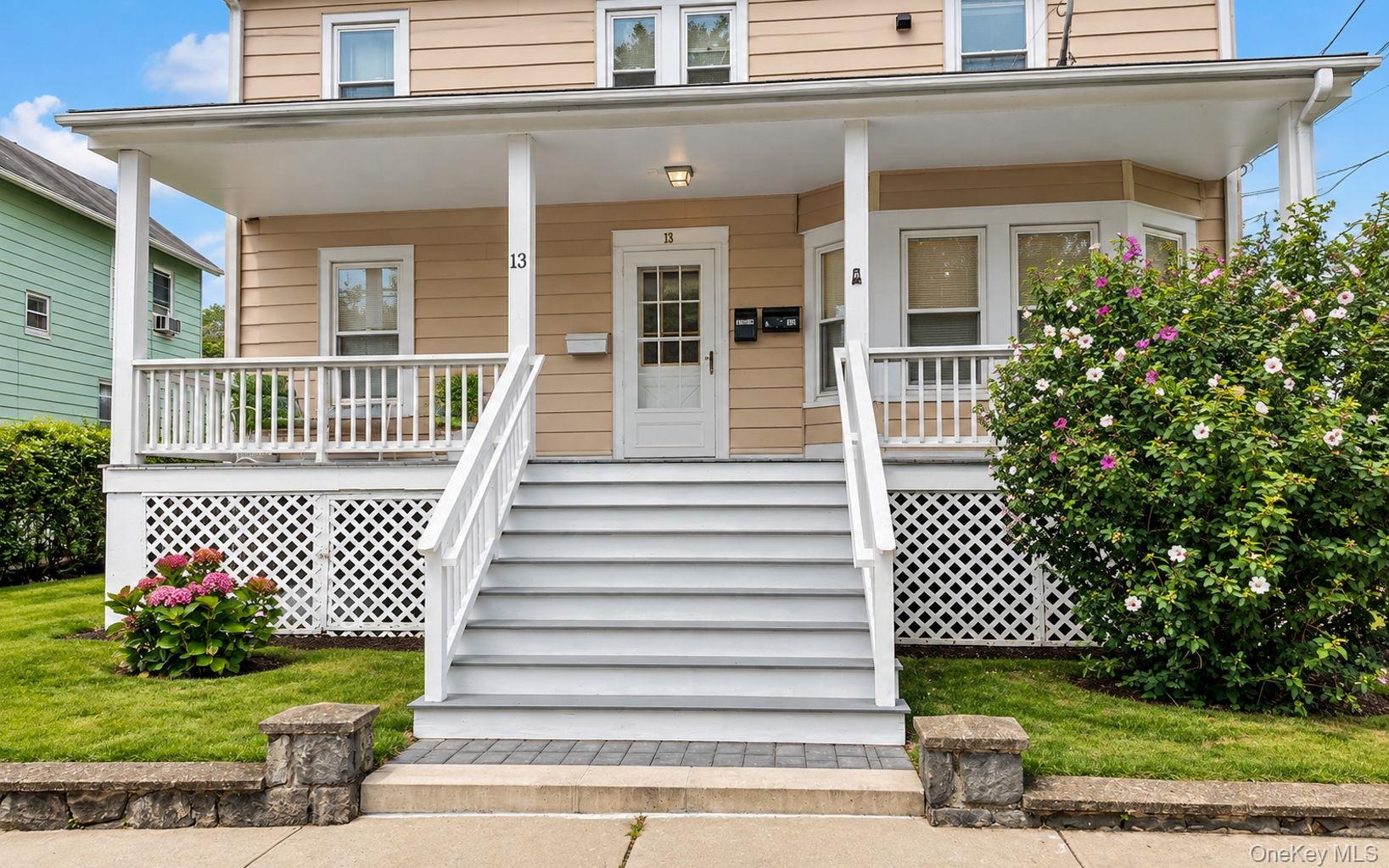 Covered front porch with white railings and lattice skirting