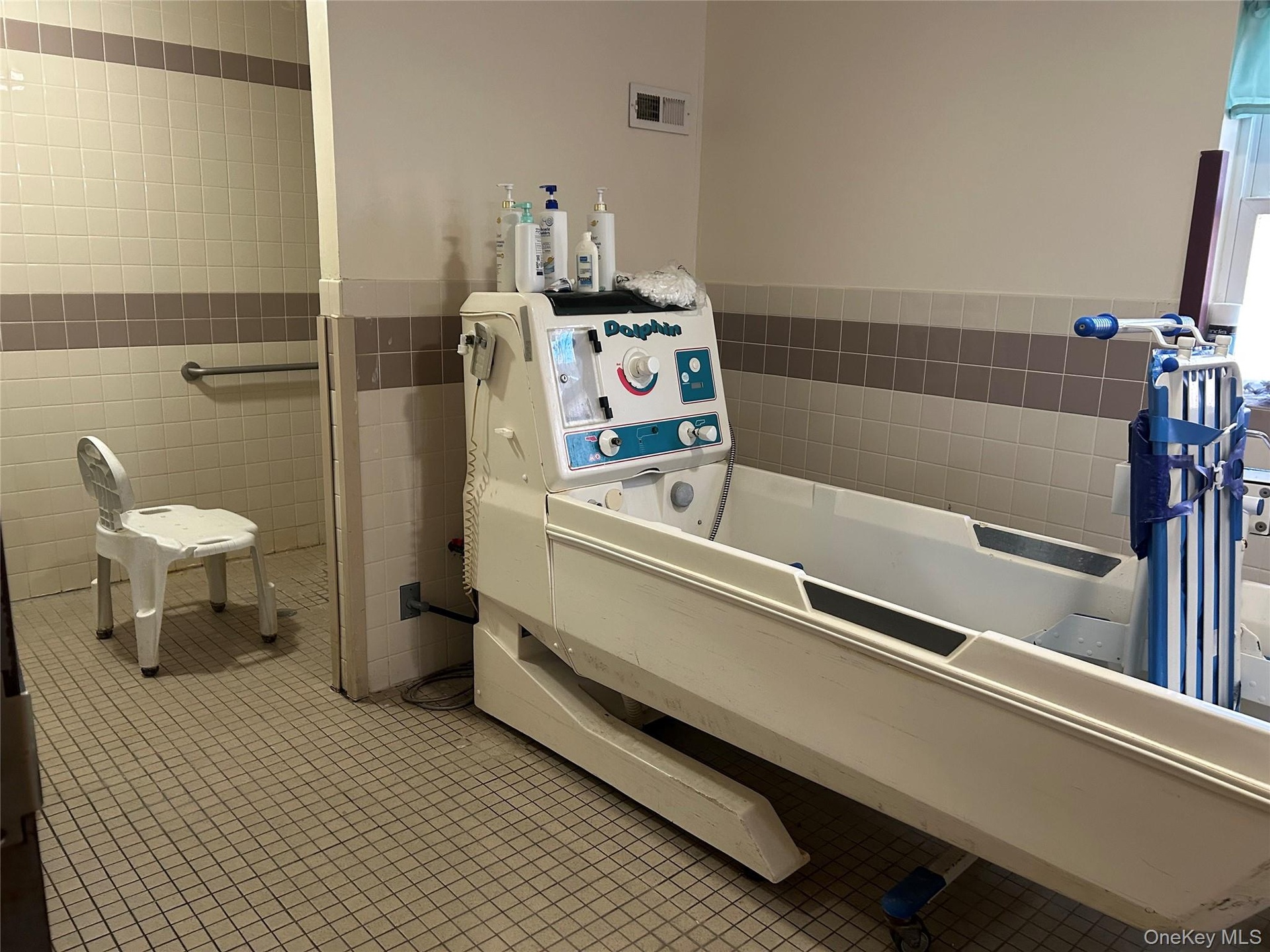 Full bathroom with tile walls, a bath, and wainscoting