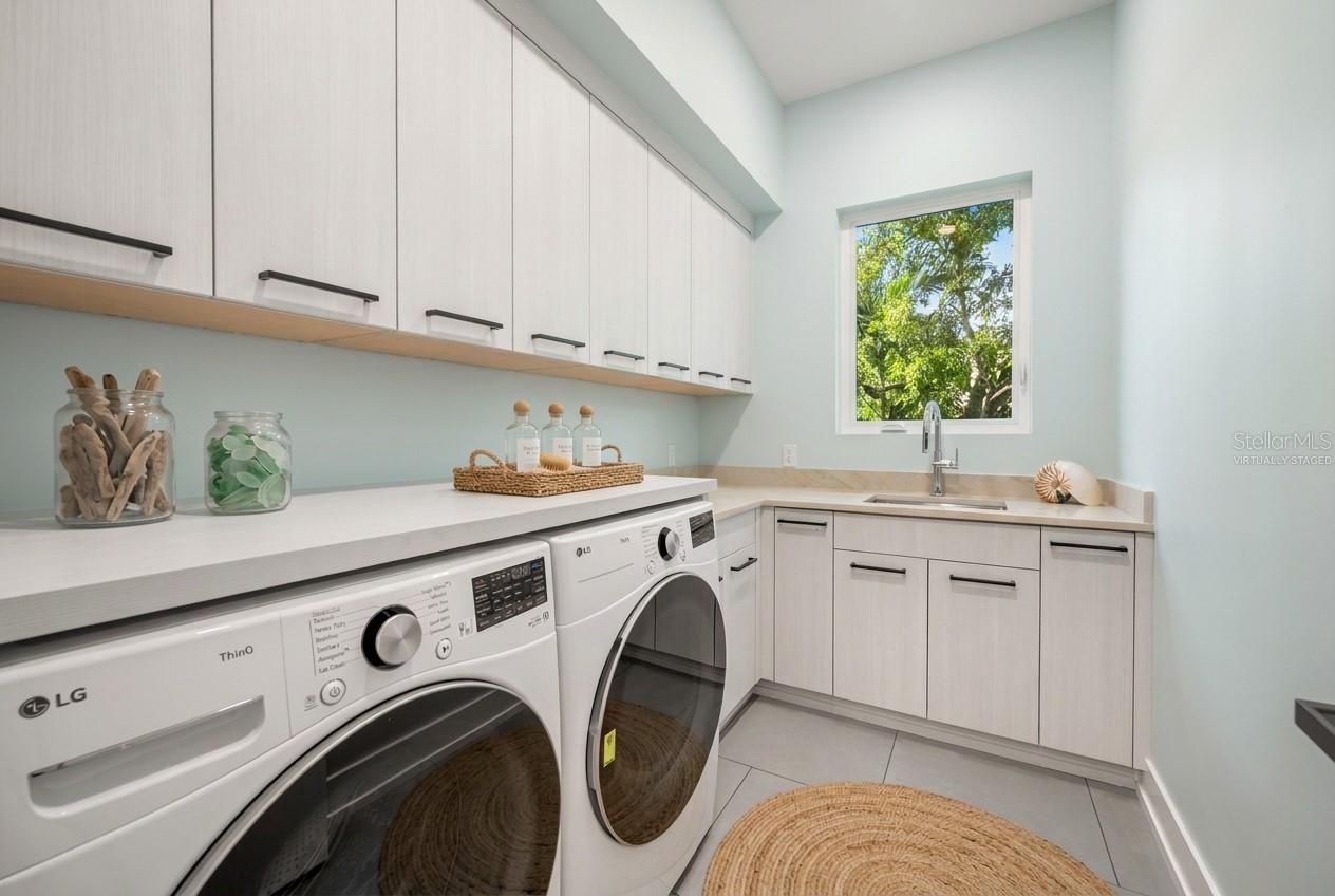 Virtually staged first-floor laundry room offering generous workspace, storage, and everyday convenience.
