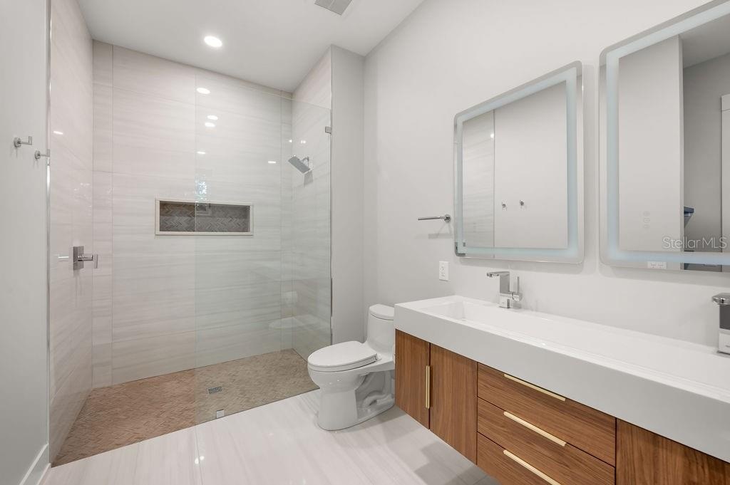 Beautifully designed guest bath featuring custom tile work and sophisticated finishes.