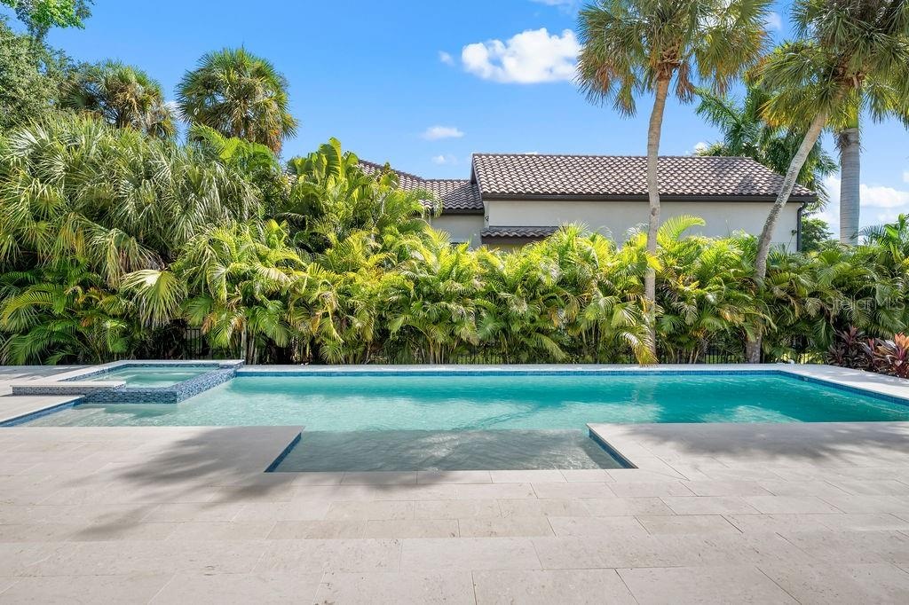 Heated saltwater pool has spa as well with plenty of sunlight and privacy.