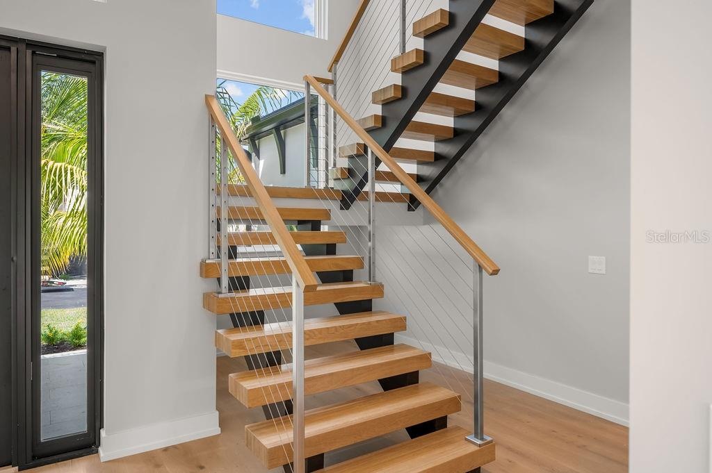 Custom designed staircase leading to second floor leading to 3 additional en suite bedrooms.