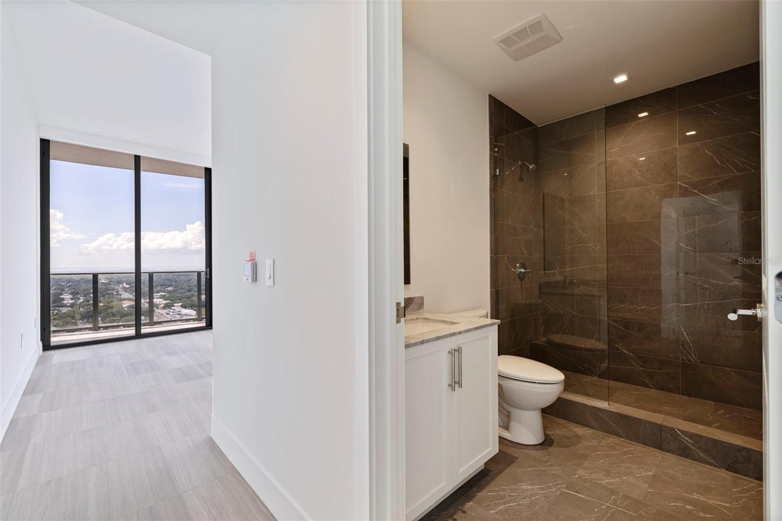 Bedroom 2: A private guest suite with its own en-suite bath and balcony access—comfort that feels considered.