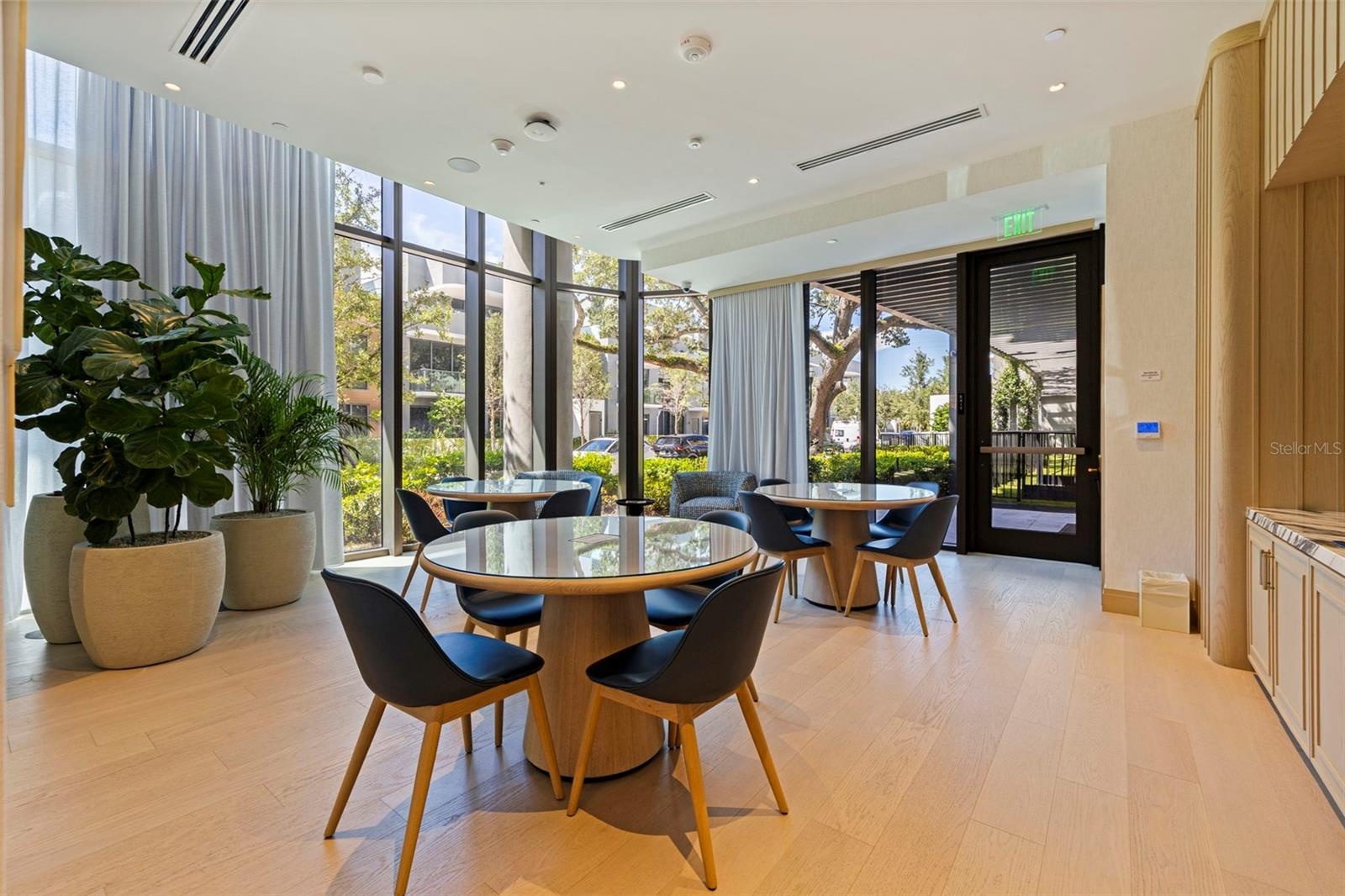 Casual resident gathering space framed by natural light and greenery.