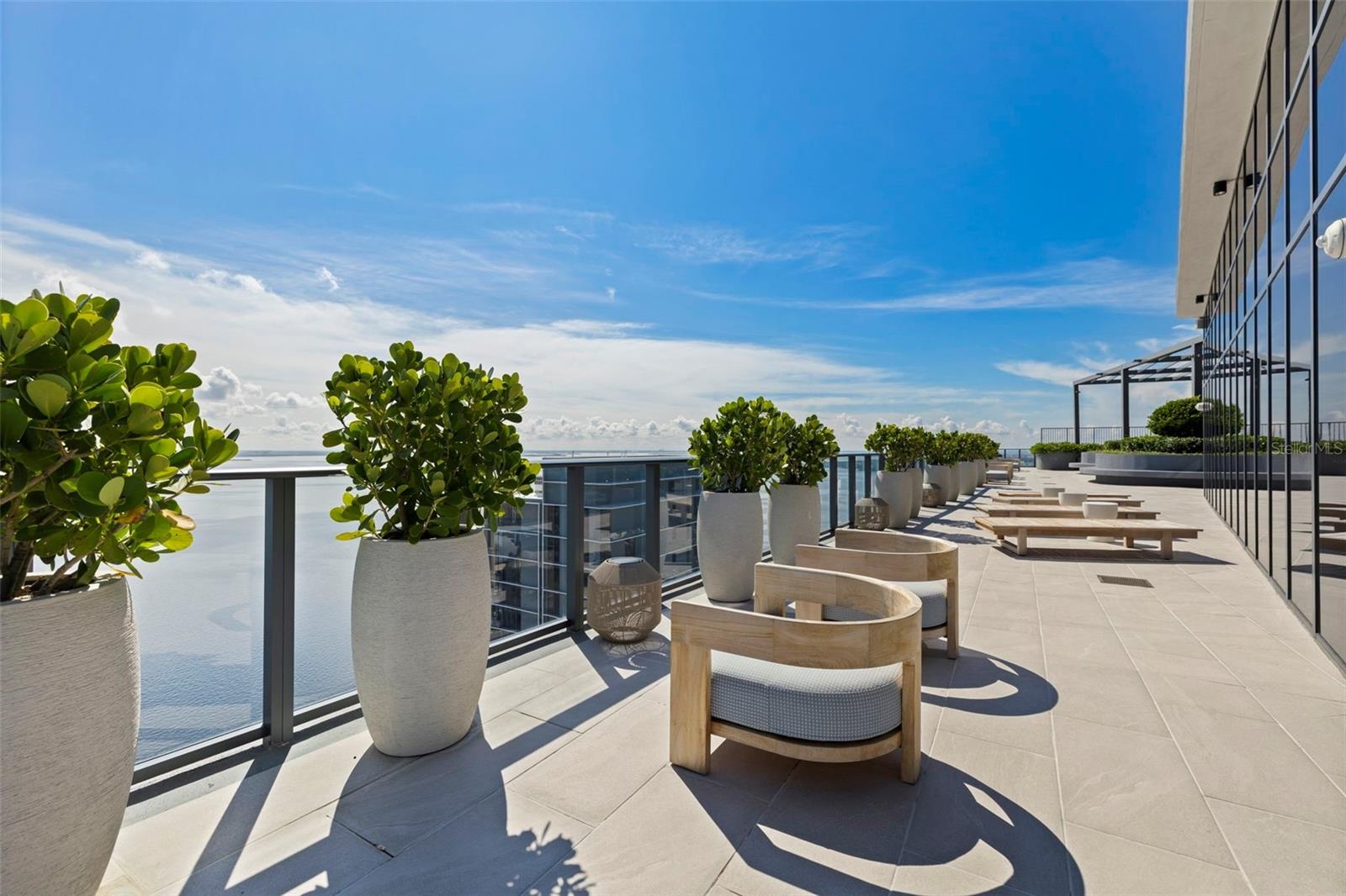 Indoor-outdoor living continues across an expansive waterfront terrace.