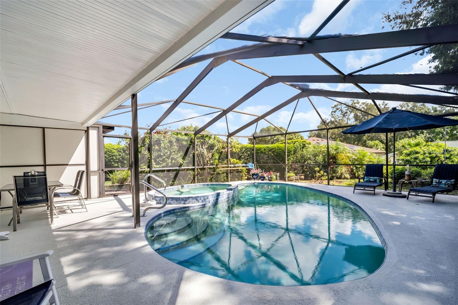 Pool & spa with screened enclosure for year-round enjoyment plus lush landscaping for privacy~