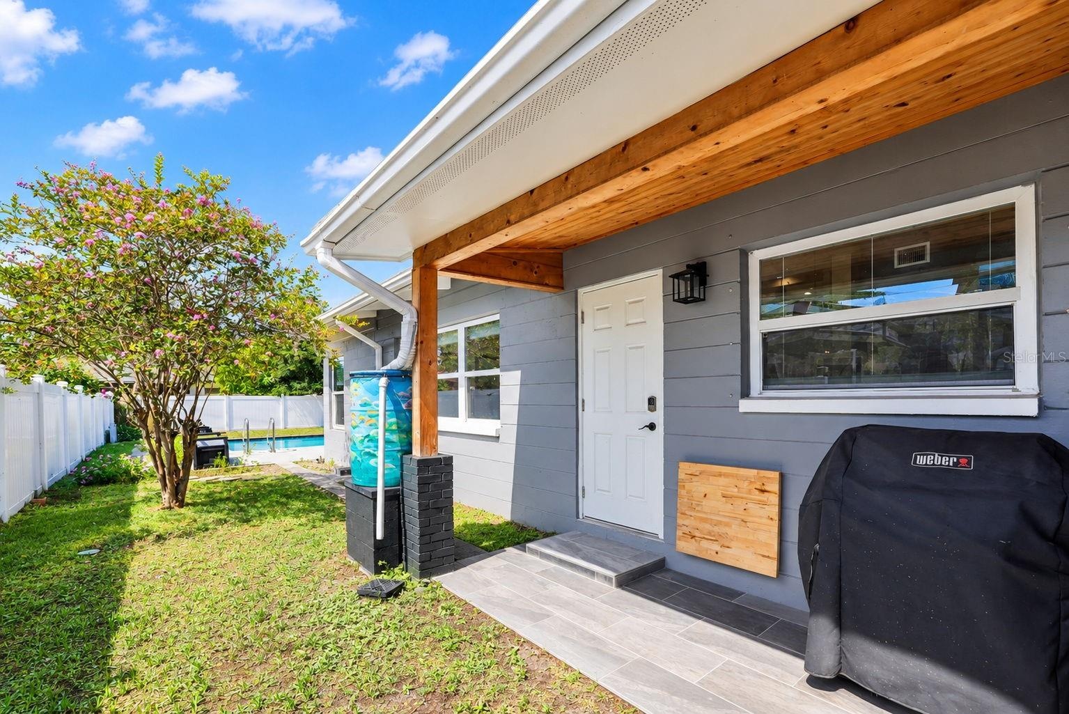 covered patio area with rain barrels catching water from the gutters