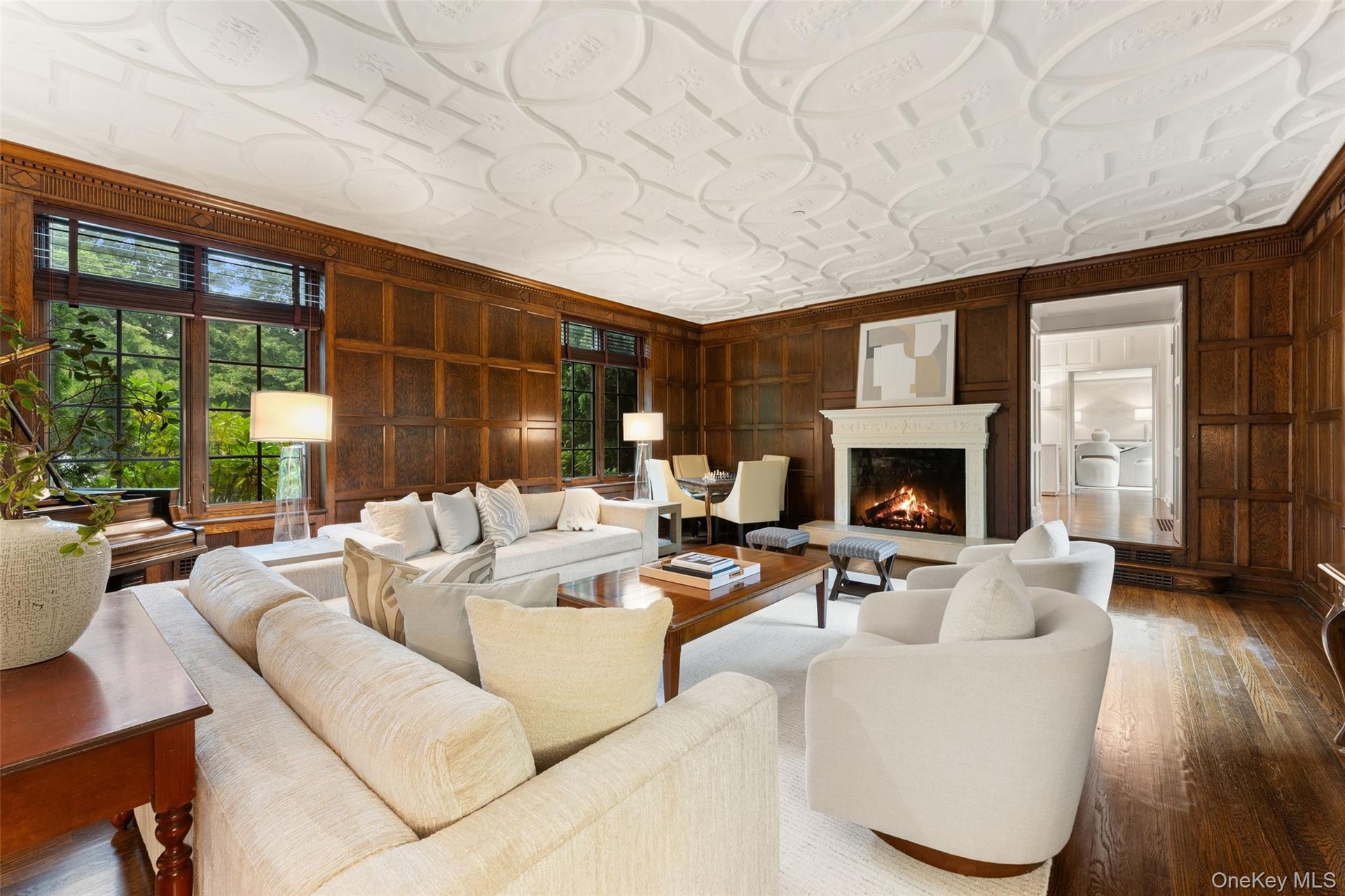 View of living room and gas fireplace with custom millwork on ceiling