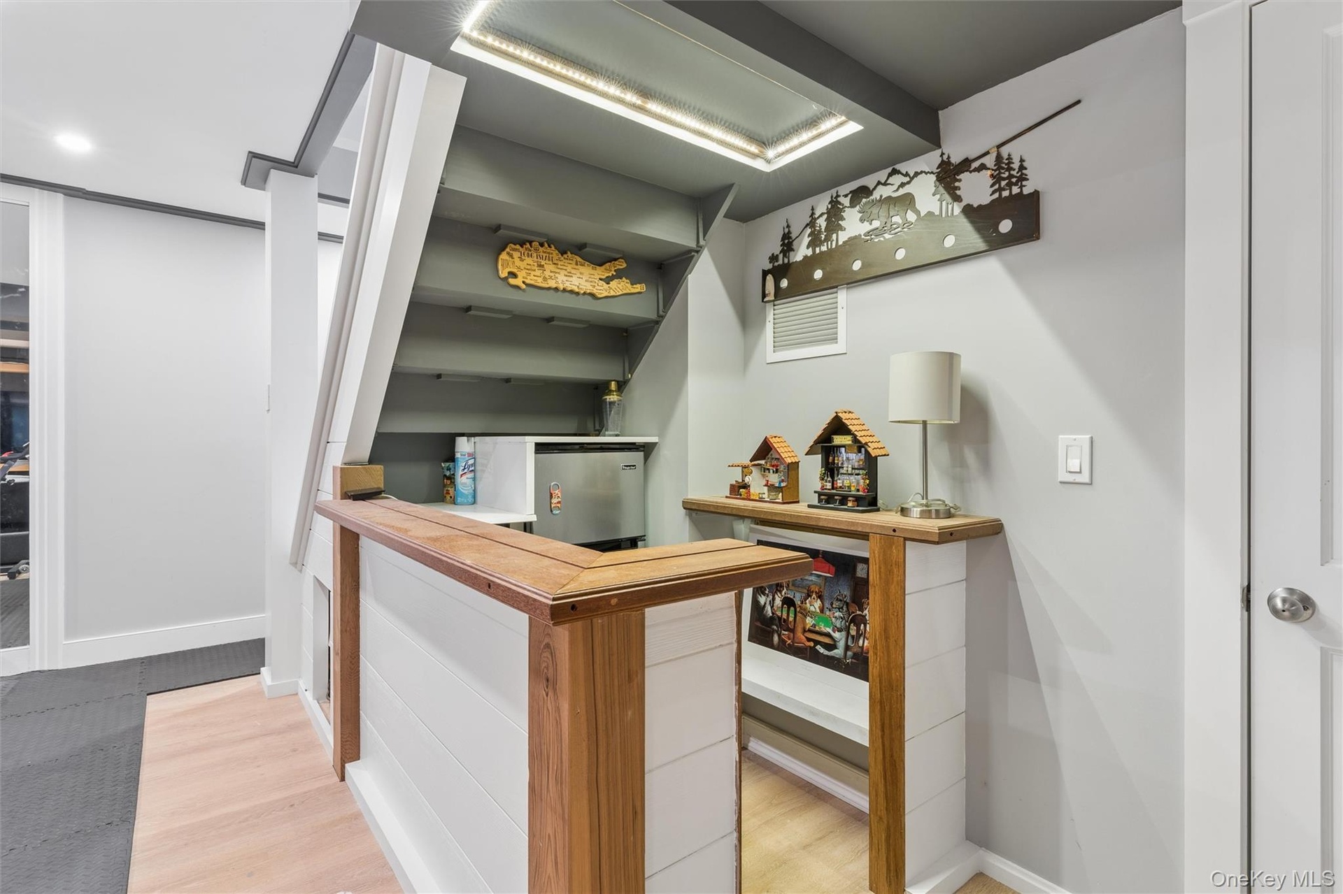 Custom bar featuring a wood-finish countertop, shiplap paneling, and a compact refrigerator