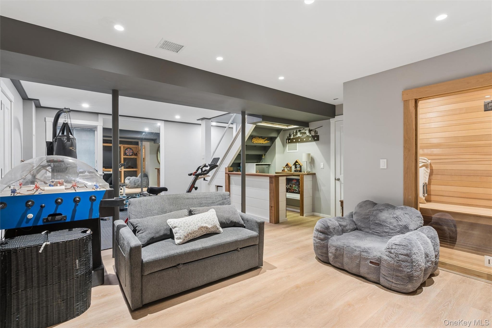 Light wood-finish flooring, built-in dry sauna, recessed lighting, and a white and wood-finish accent bar