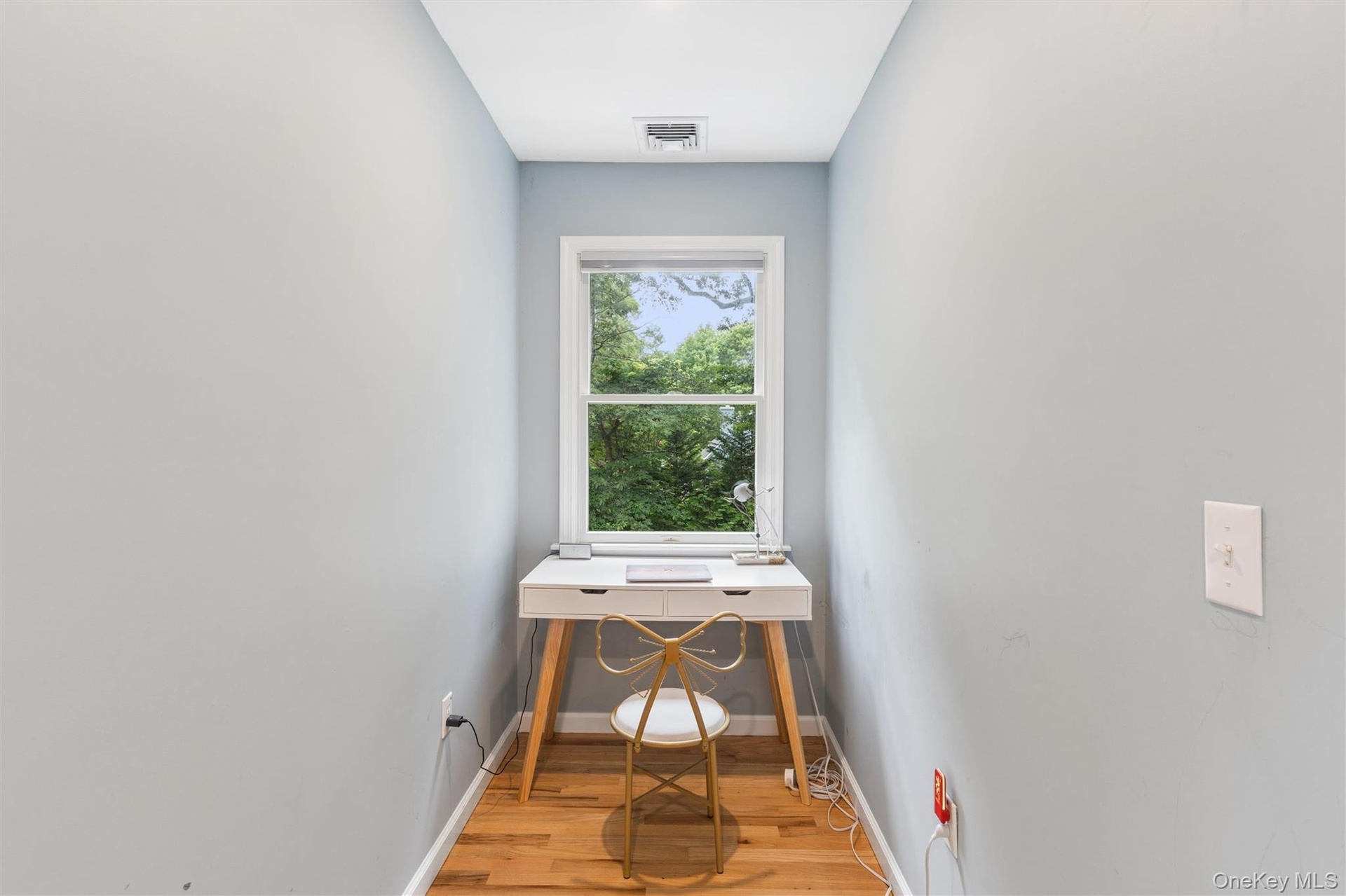 Windowed alcove featuring wood-finish flooring and light-toned walls