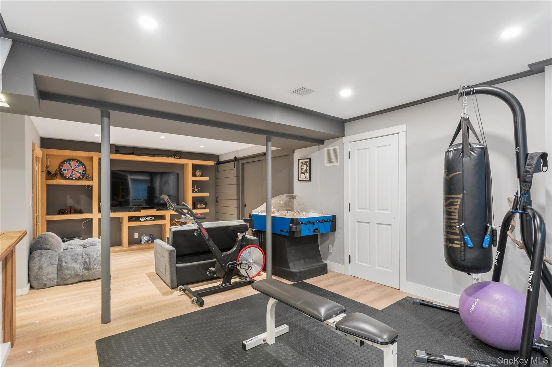 Recessed lighting illuminates the open-concept space with wood-finish flooring