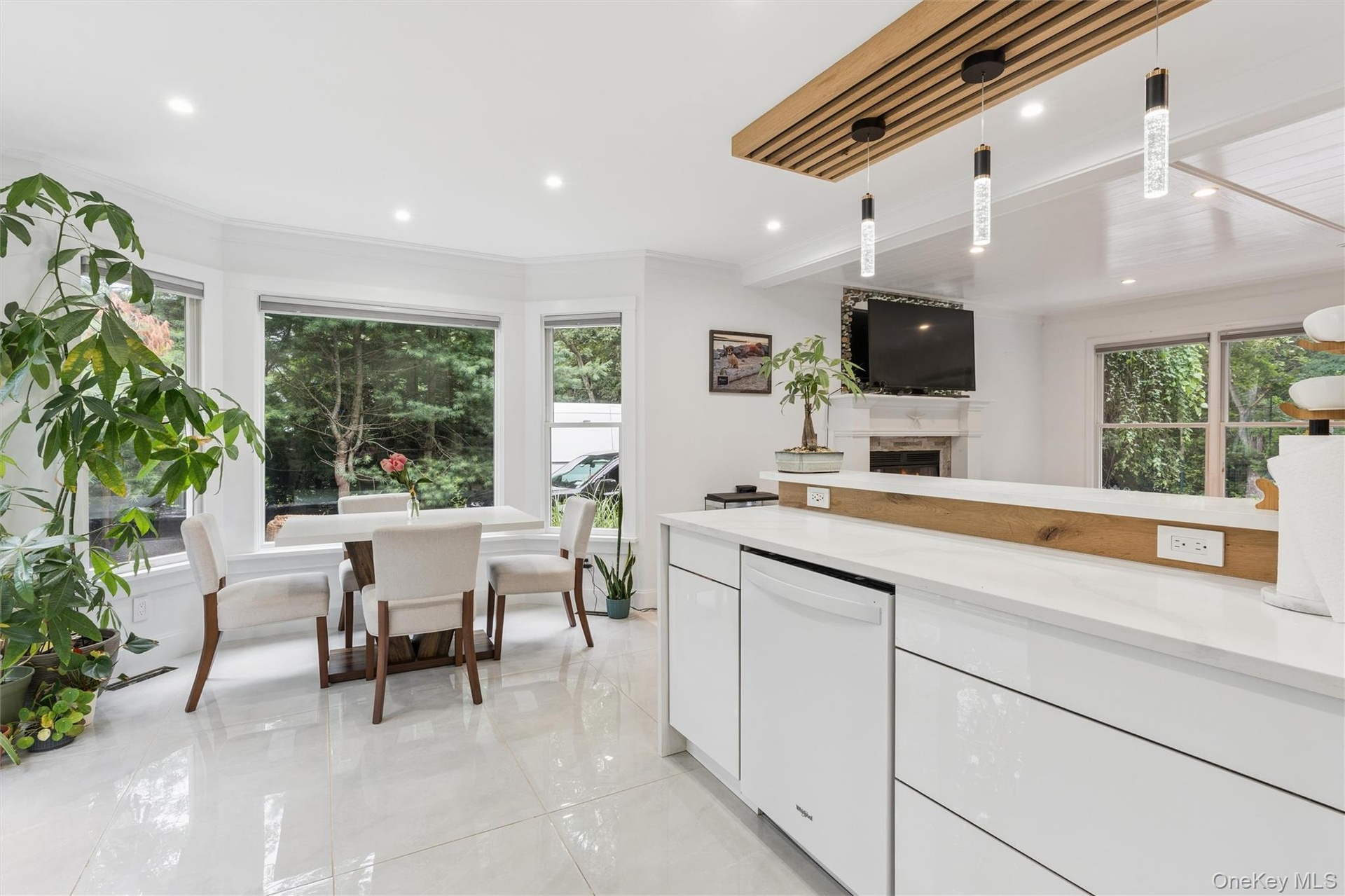 White tile flooring, bay window, recessed lighting, and a modern kitchen island with an integrated dishwasher