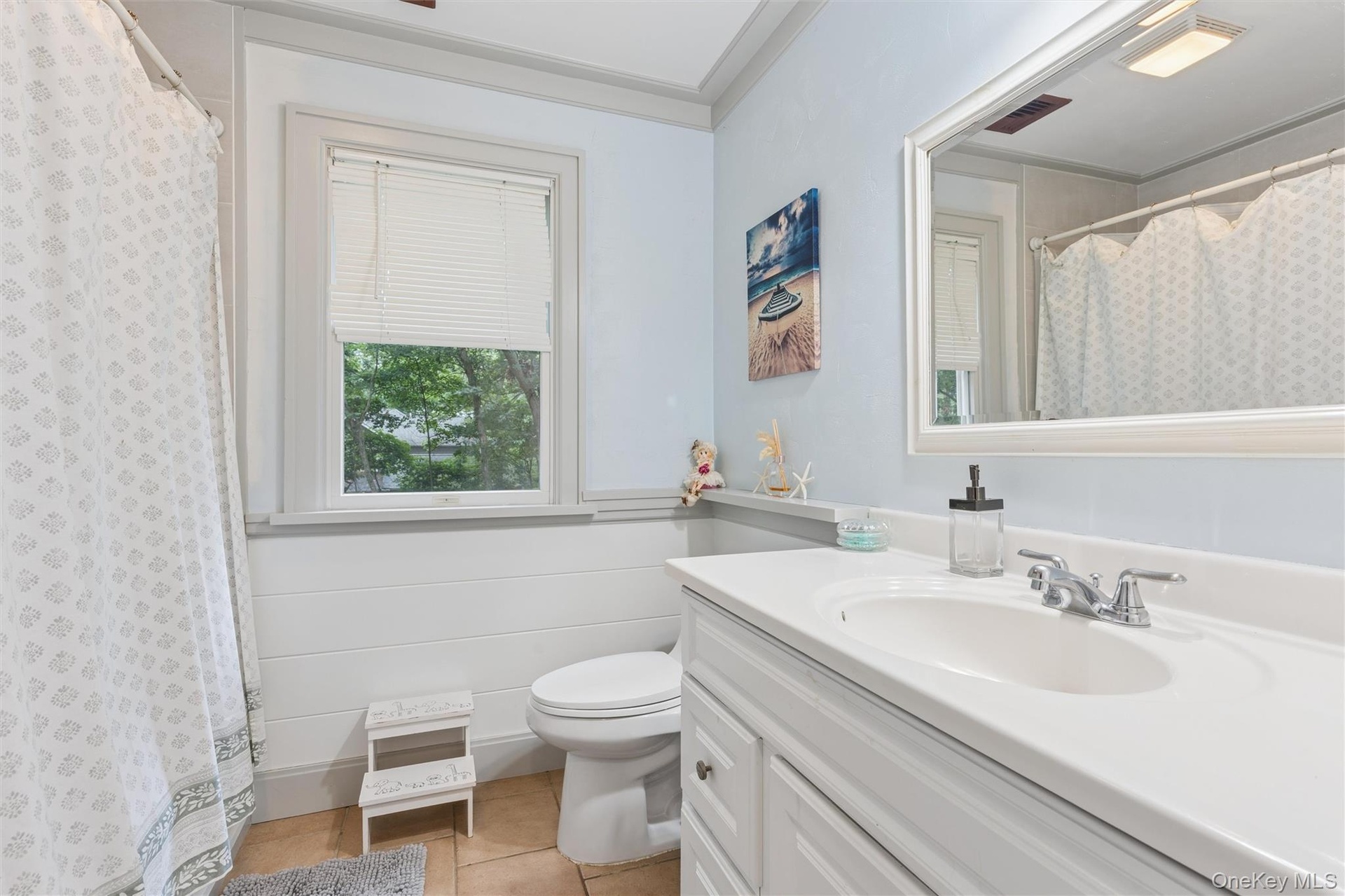 White vanity with a single basin sink, chrome faucet, and integrated countertop