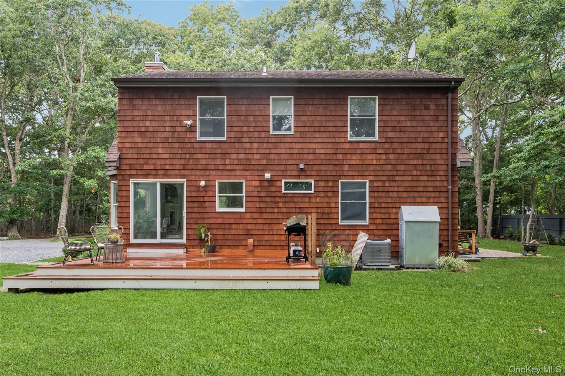 Wood-shingle exterior with multiple windows and a sliding glass door