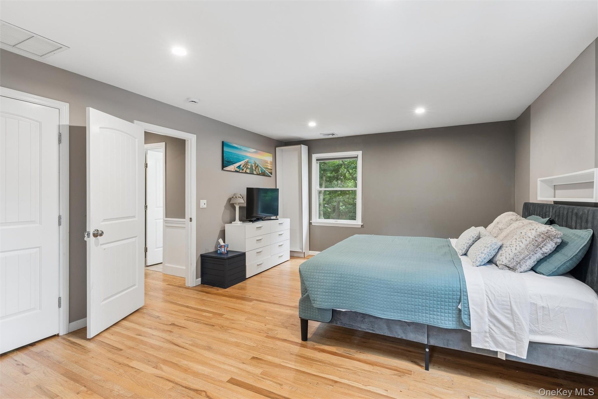 Hardwood flooring, recessed lighting, white interior doors, and a window with natural light