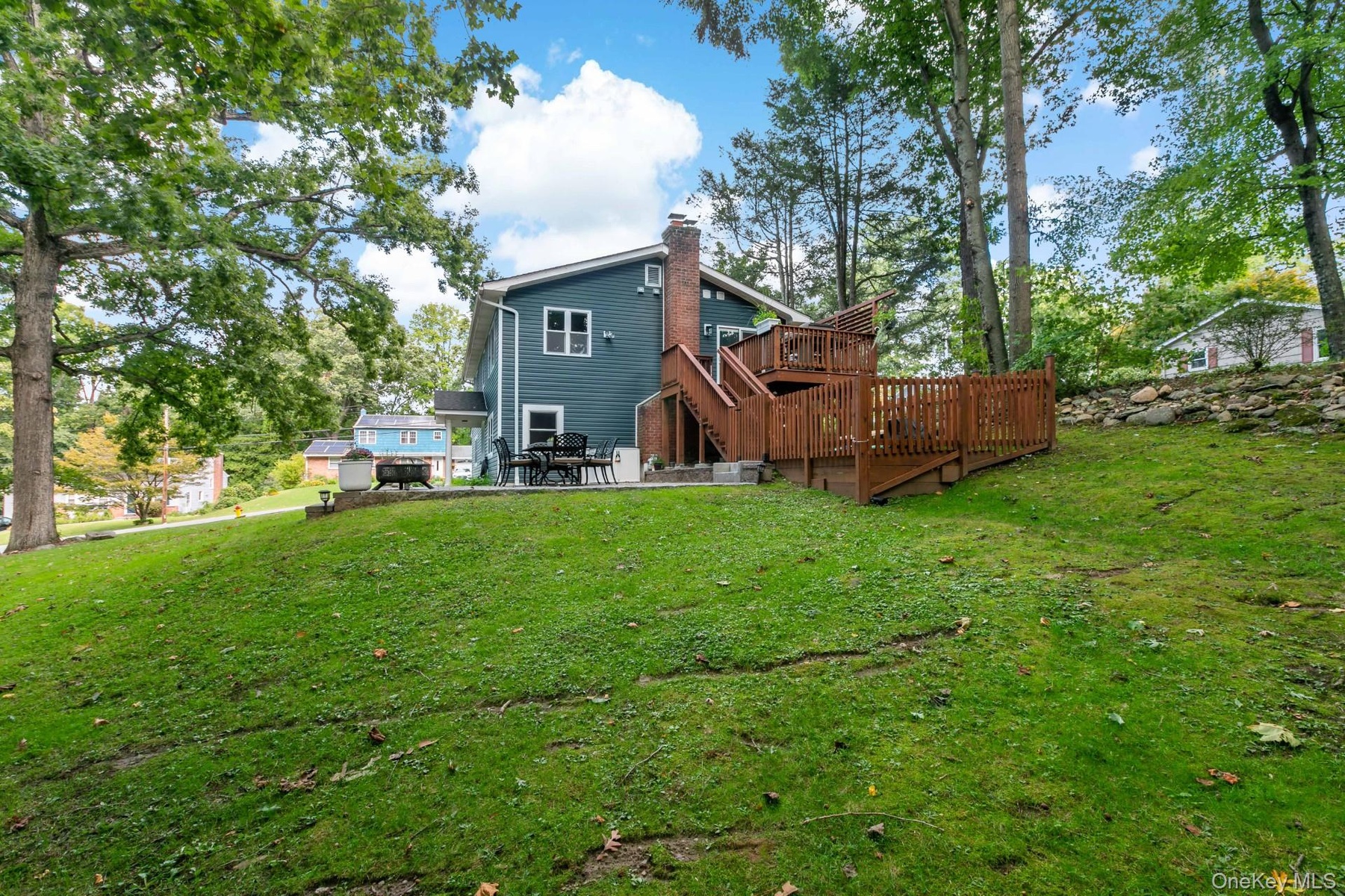 Side view with yard, deck and patio
