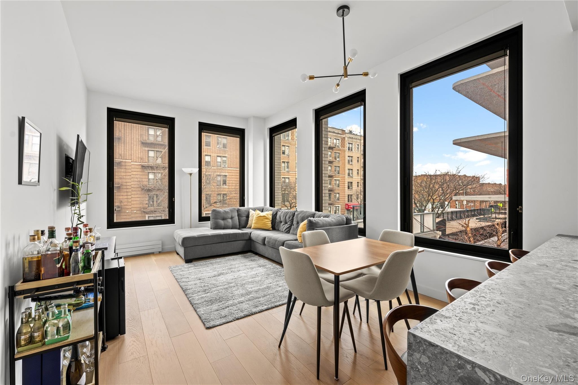 Dining area featuring light wood-type flooring, a chandelier, healthy amount of natural light, and a baseboard heating unit