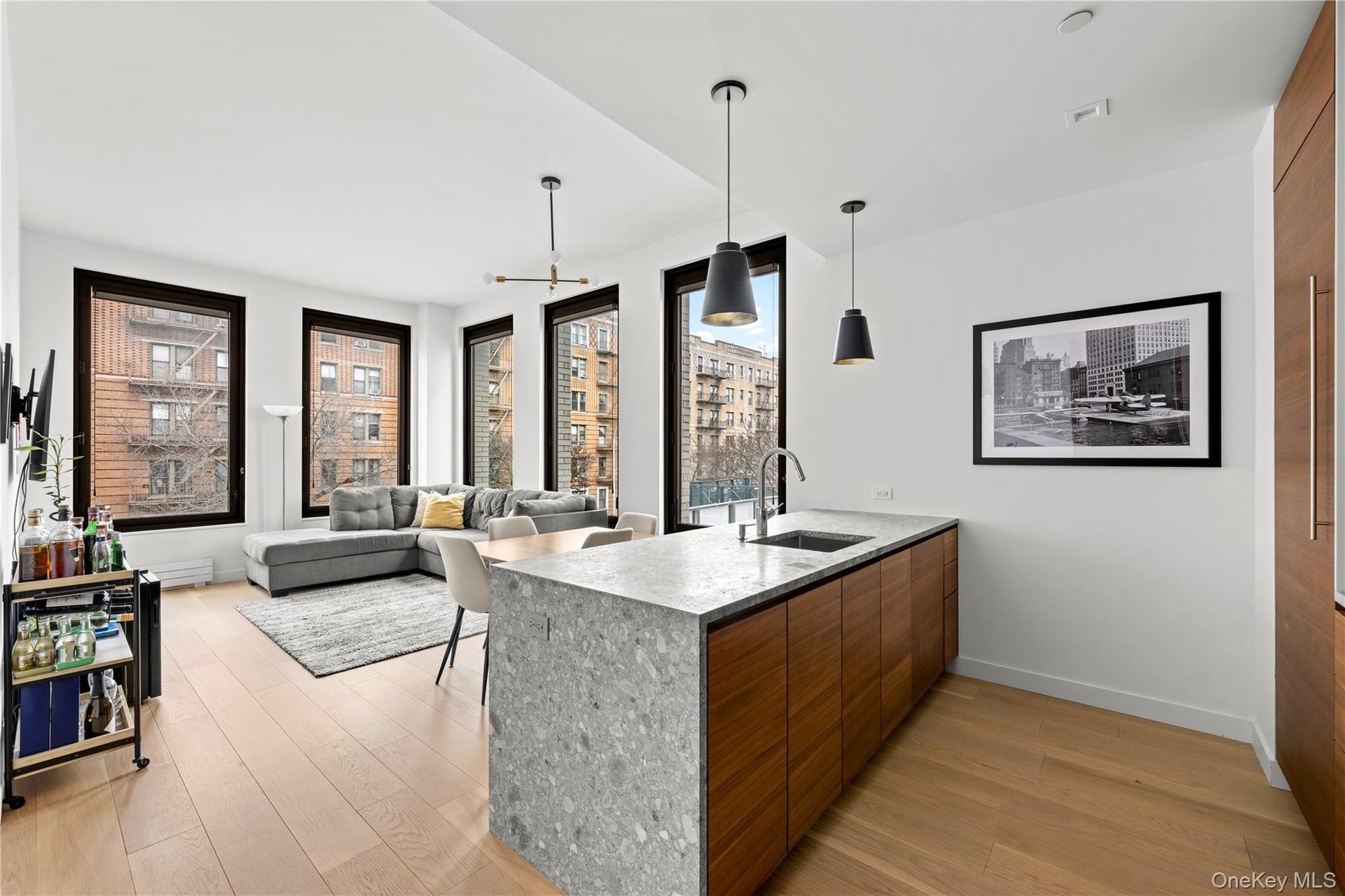 Kitchen featuring decorative light fixtures, modern cabinets, light wood-style floors, a peninsula, and brown cabinetry