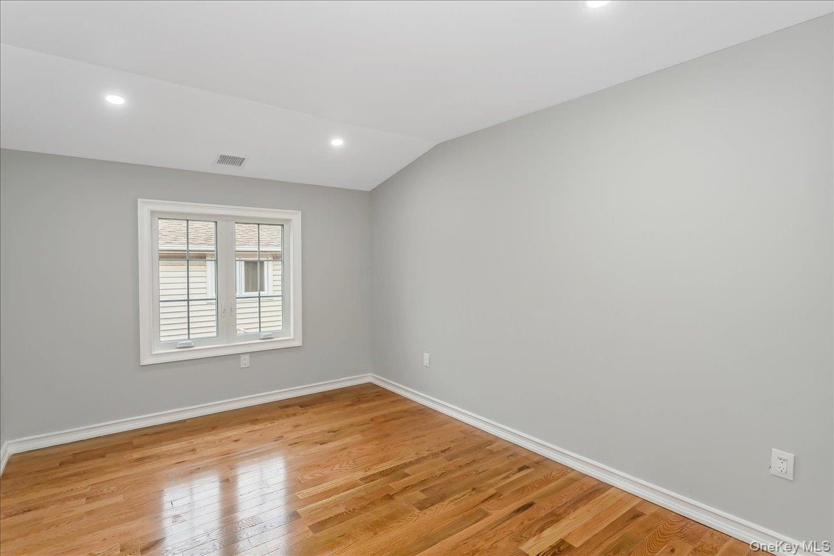 Unfurnished room with recessed lighting, light wood finished floors, and lofted ceiling
