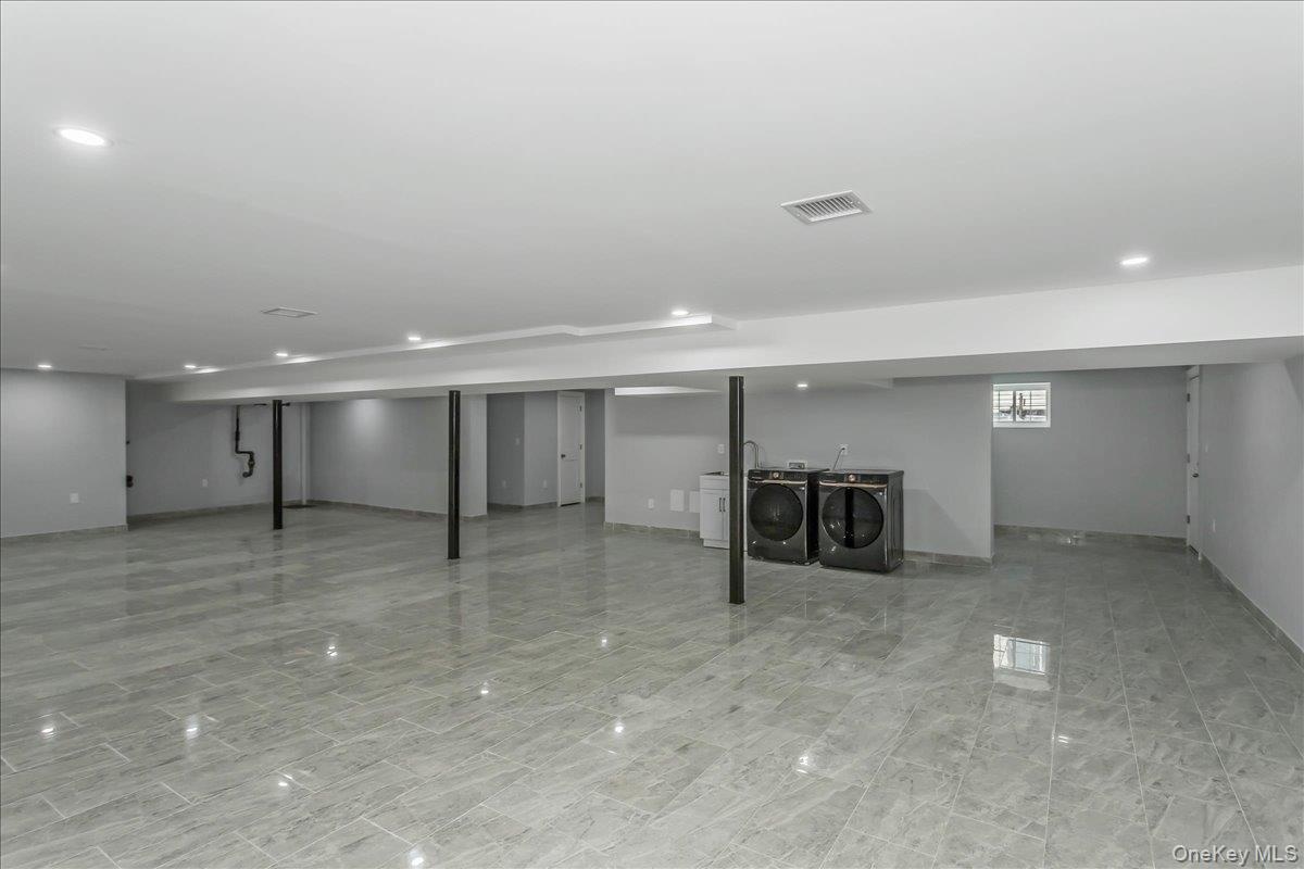 Basement with independent washer and dryer and recessed lighting