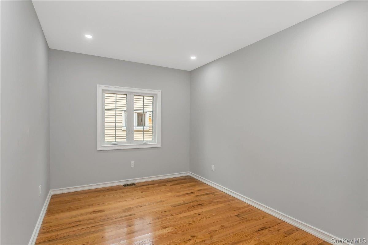 Empty room featuring light wood-style floors and recessed lighting