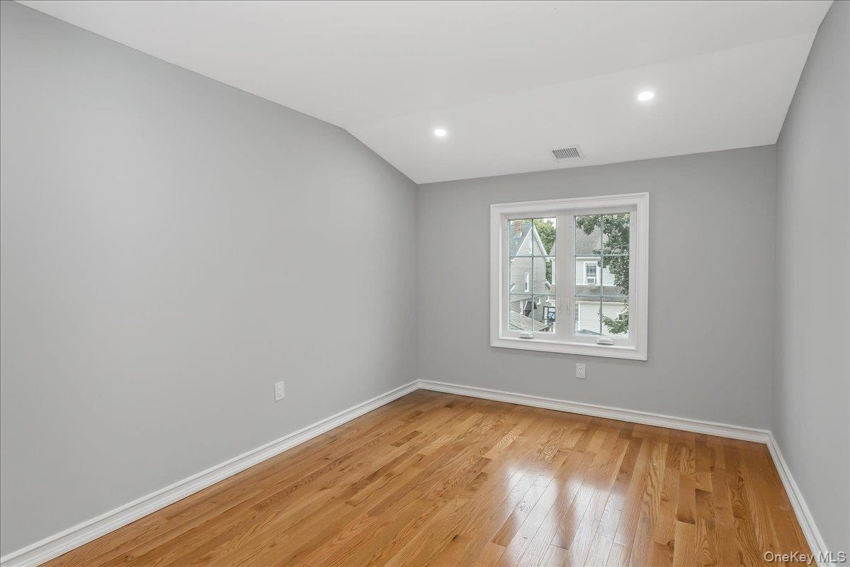Unfurnished room featuring light wood-type flooring, recessed lighting, and vaulted ceiling