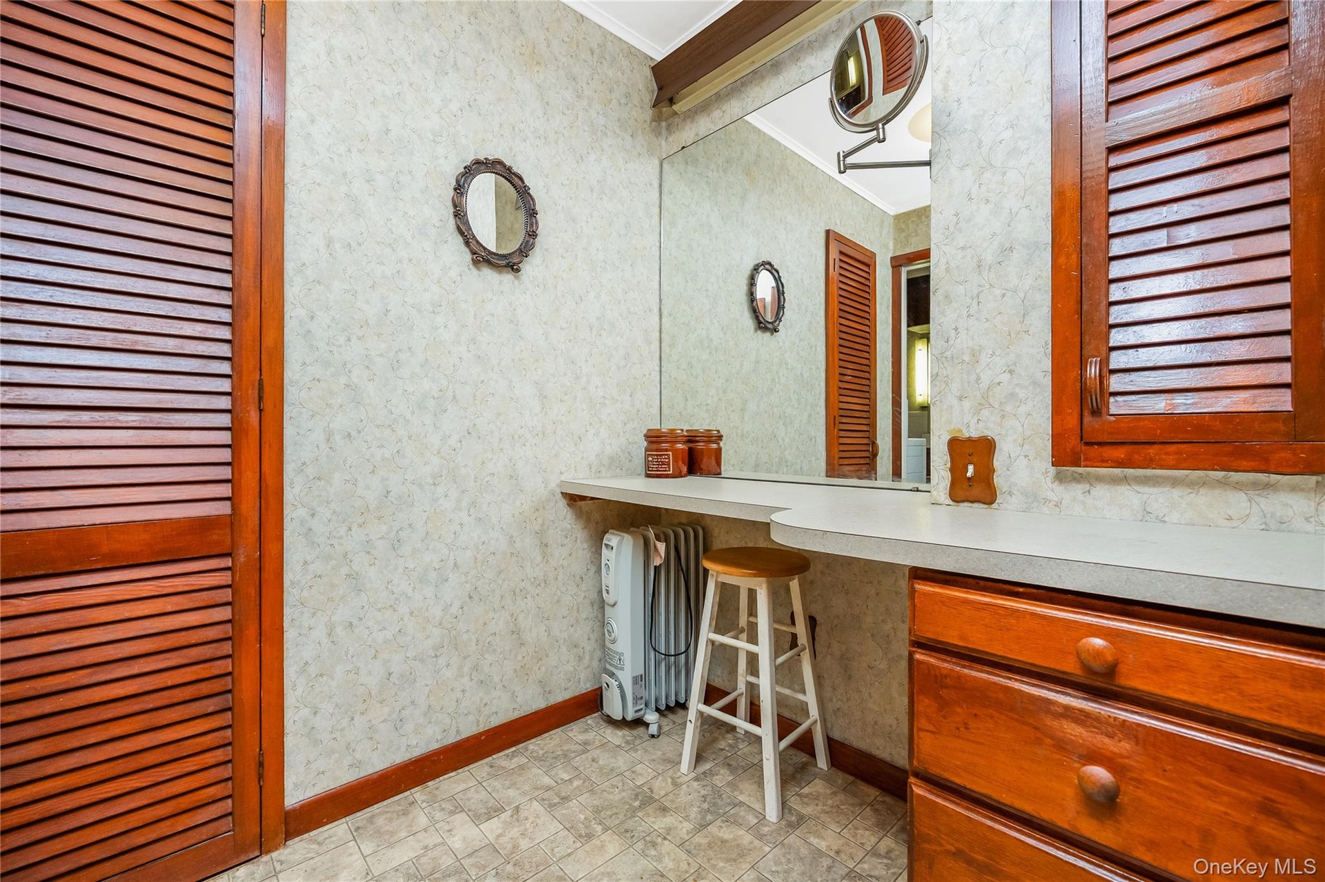 Built-in vanity with integrated storage cabinetry and a large wall-mounted mirror