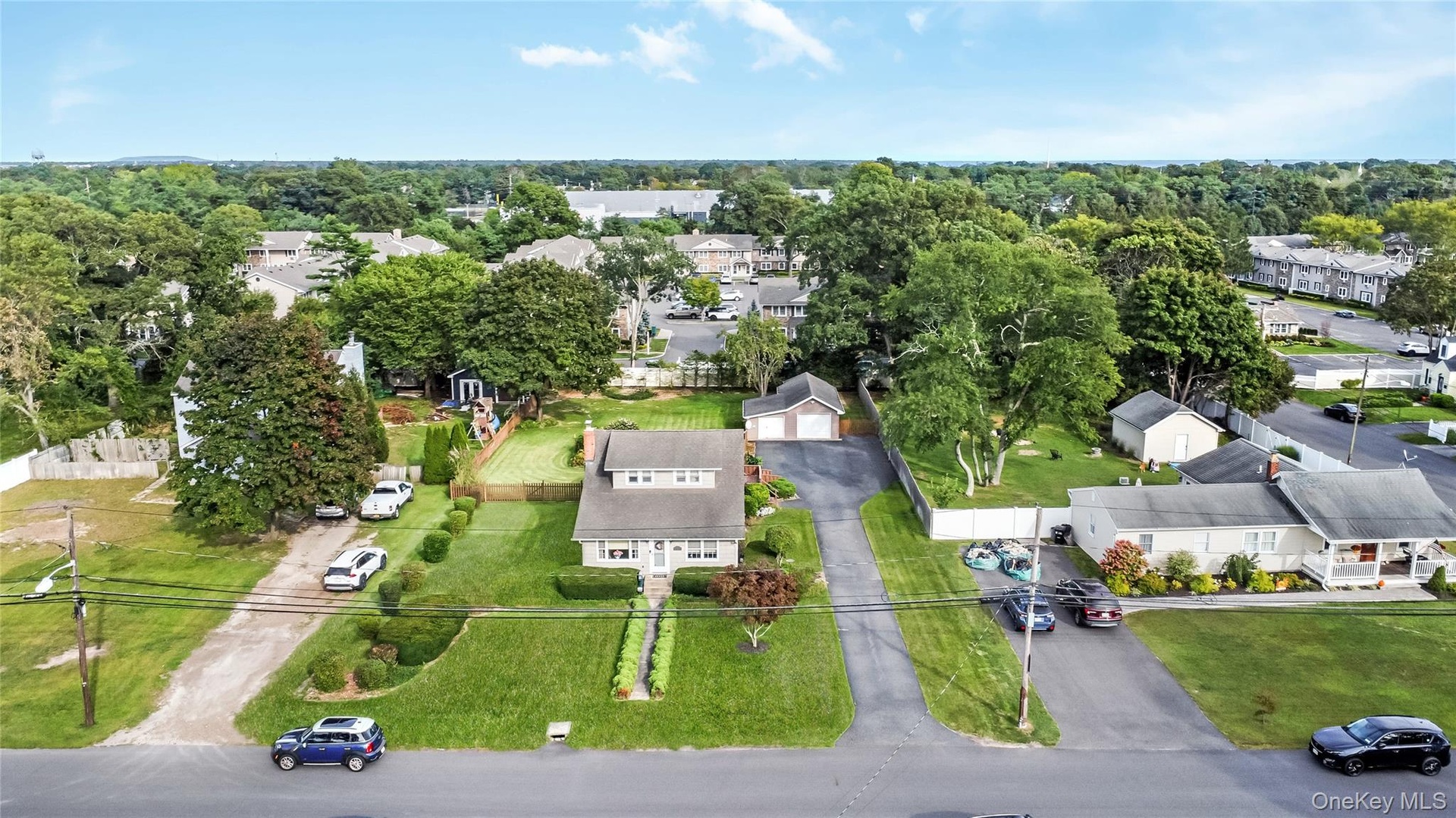 Two-story residence with dormer windows, a detached garage, and a long driveway