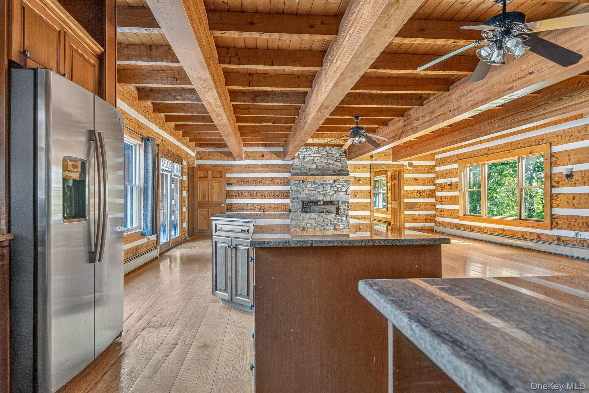 Kitchen looking to family room area with Jotul wood burning stove within the second stone fireplace.