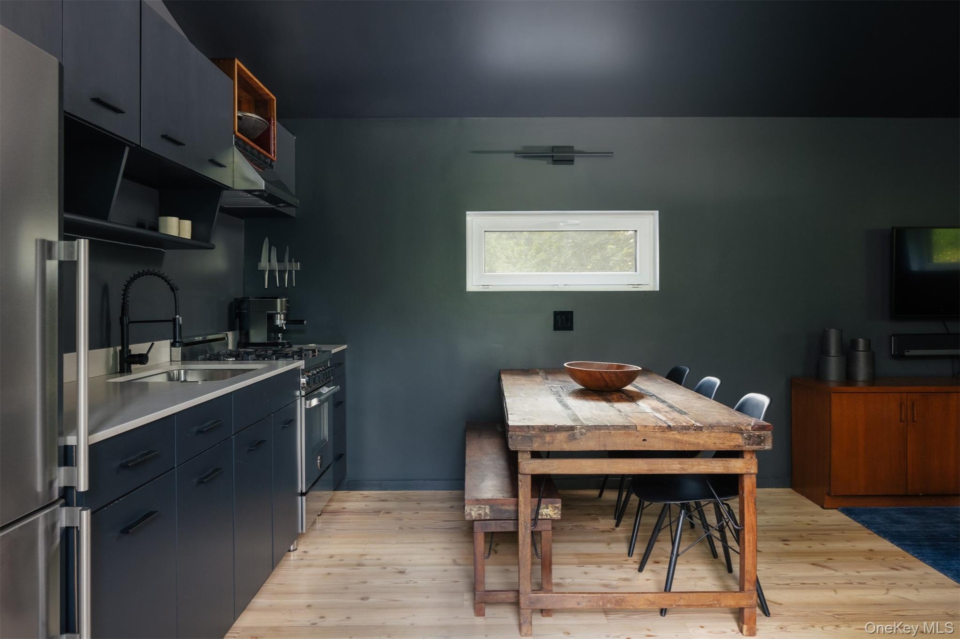 Kitchen featuring open shelves, stainless steel appliances, light wood-style floors, and under cabinet range hood