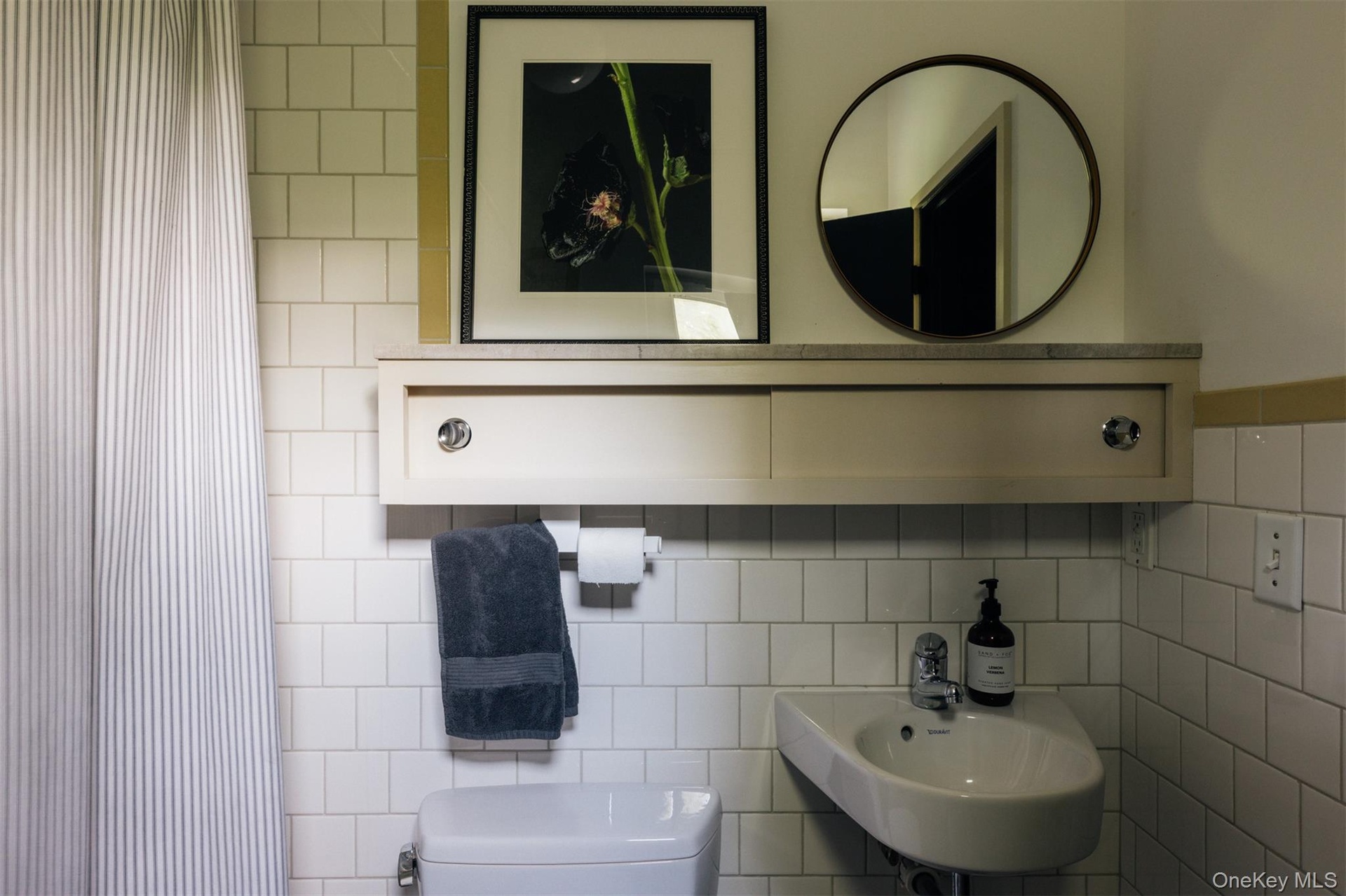 Full bathroom with curtained shower and tile walls